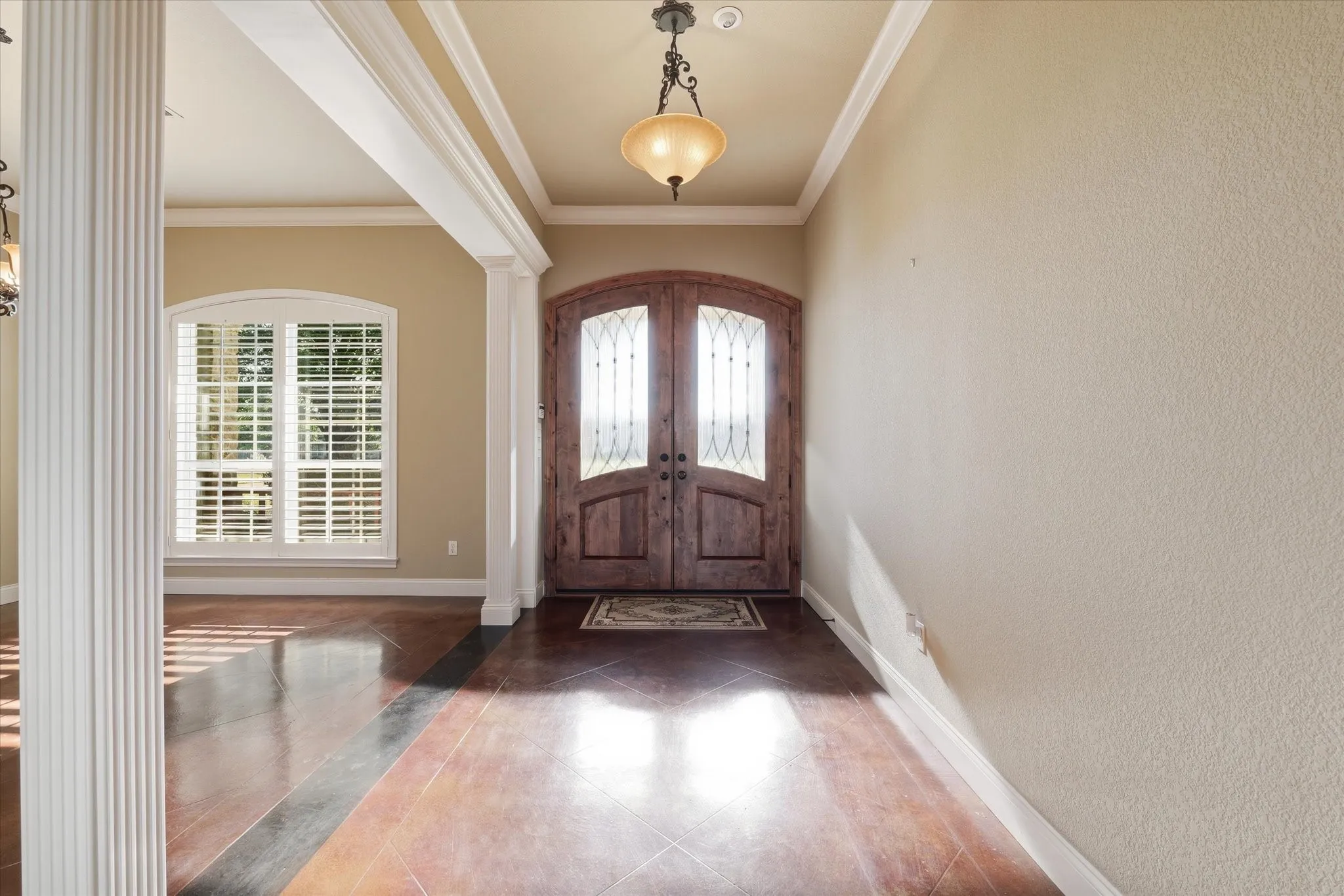 Entryway featuring a double door with decorative glass inserts, coffered ceiling, and a hanging light fixture