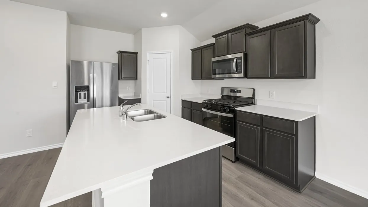 Modern kitchen featuring an expansive island with a double basin sink, dark wood-finish cabinetry, stainless steel appliances, and wood-finish flooring