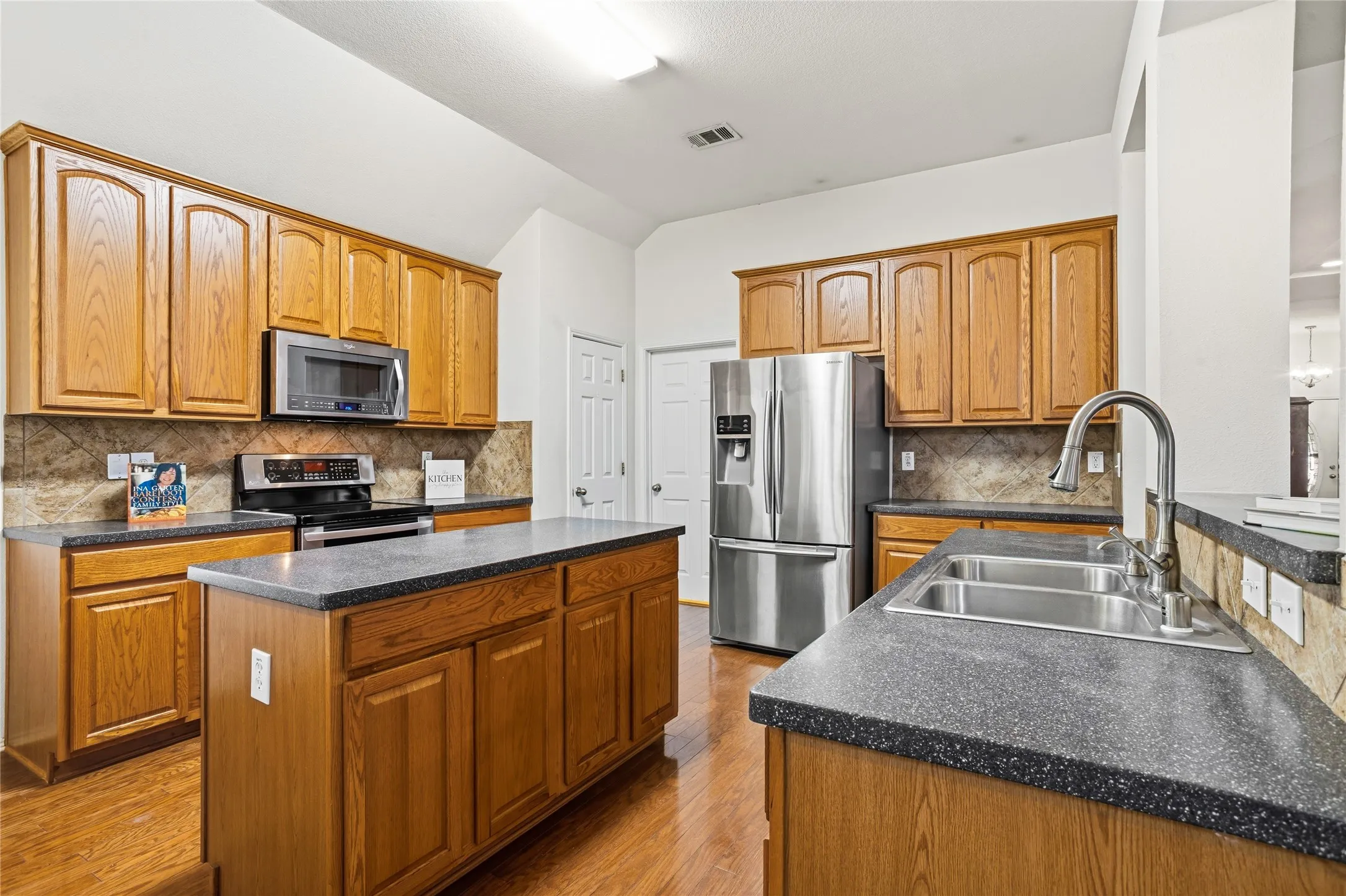 Spacious kitchen with an island and a bar.