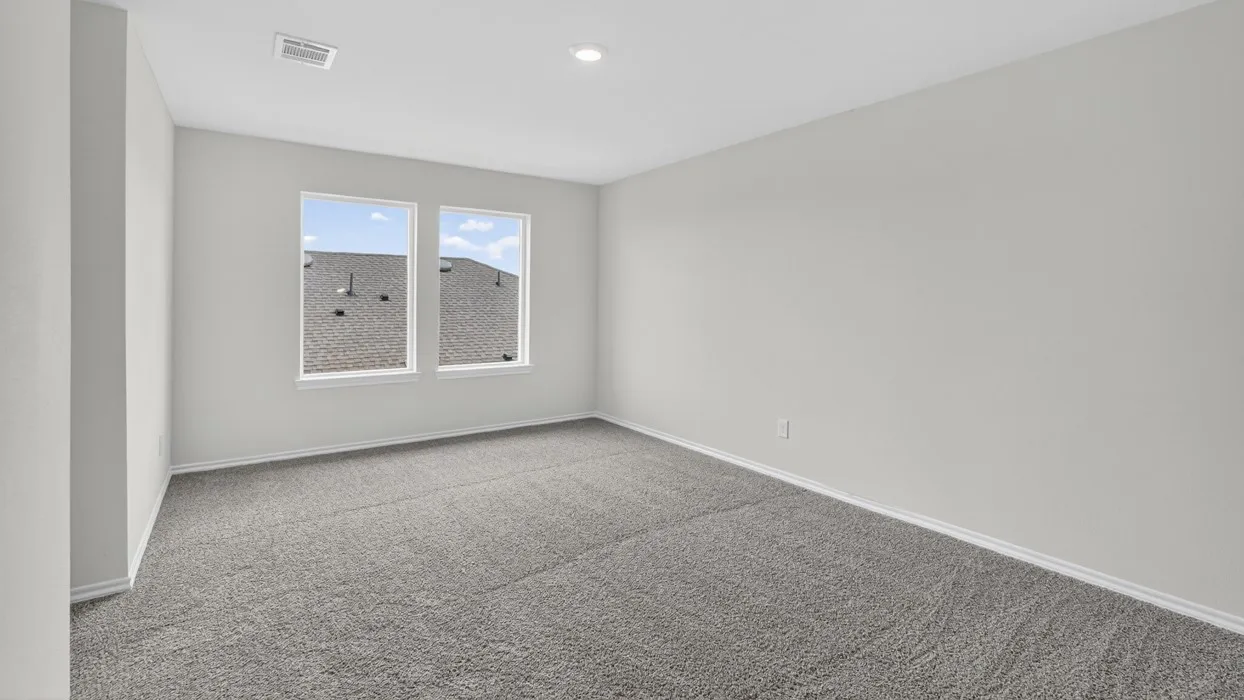 Bright interior space featuring light gray wall paint, crisp white trim, and plush gray carpeting