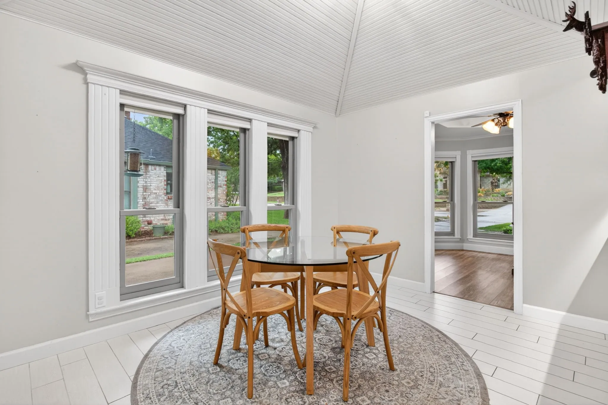 White plank flooring with a patterned area rug