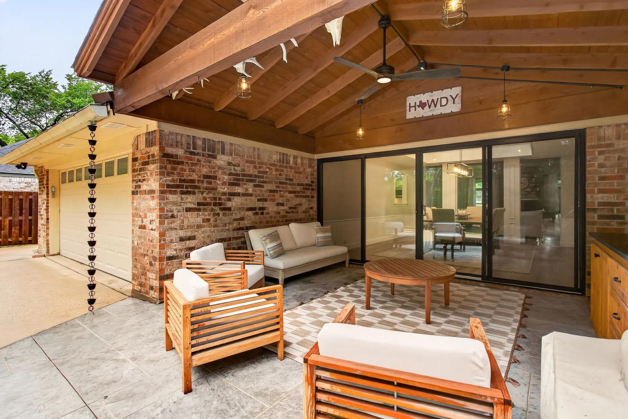 Covered patio featuring a high vaulted wood-finish ceiling with exposed beams, recessed lighting, and ceiling fans