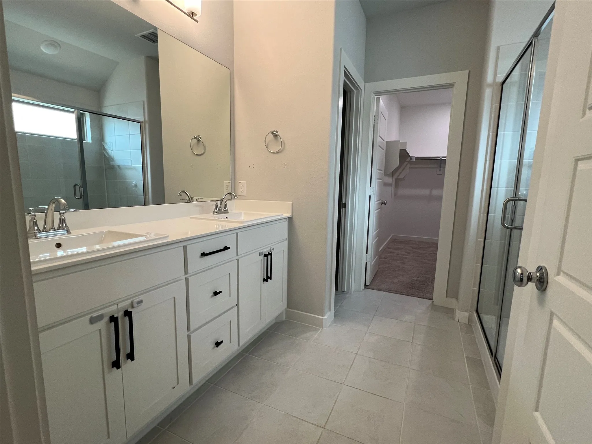 Primary Bathroom Suite featuring a dual-sink vanity with white cabinetry, polished countertop, and chrome fixtures