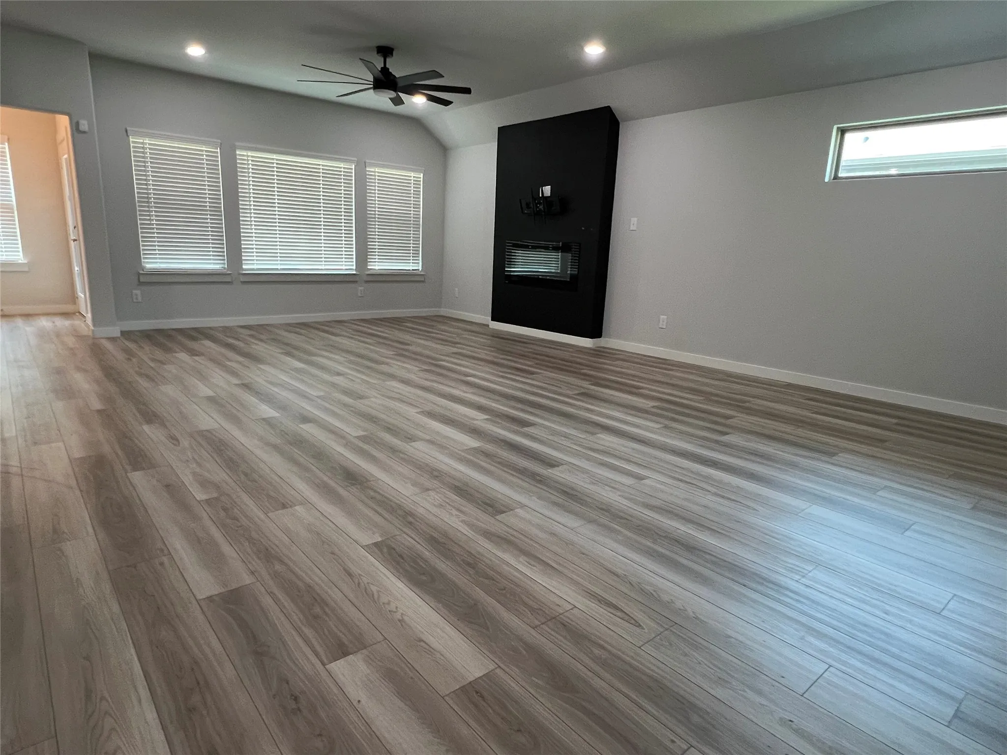Wood-finish flooring throughout, recessed lighting, and a modern ceiling fan
