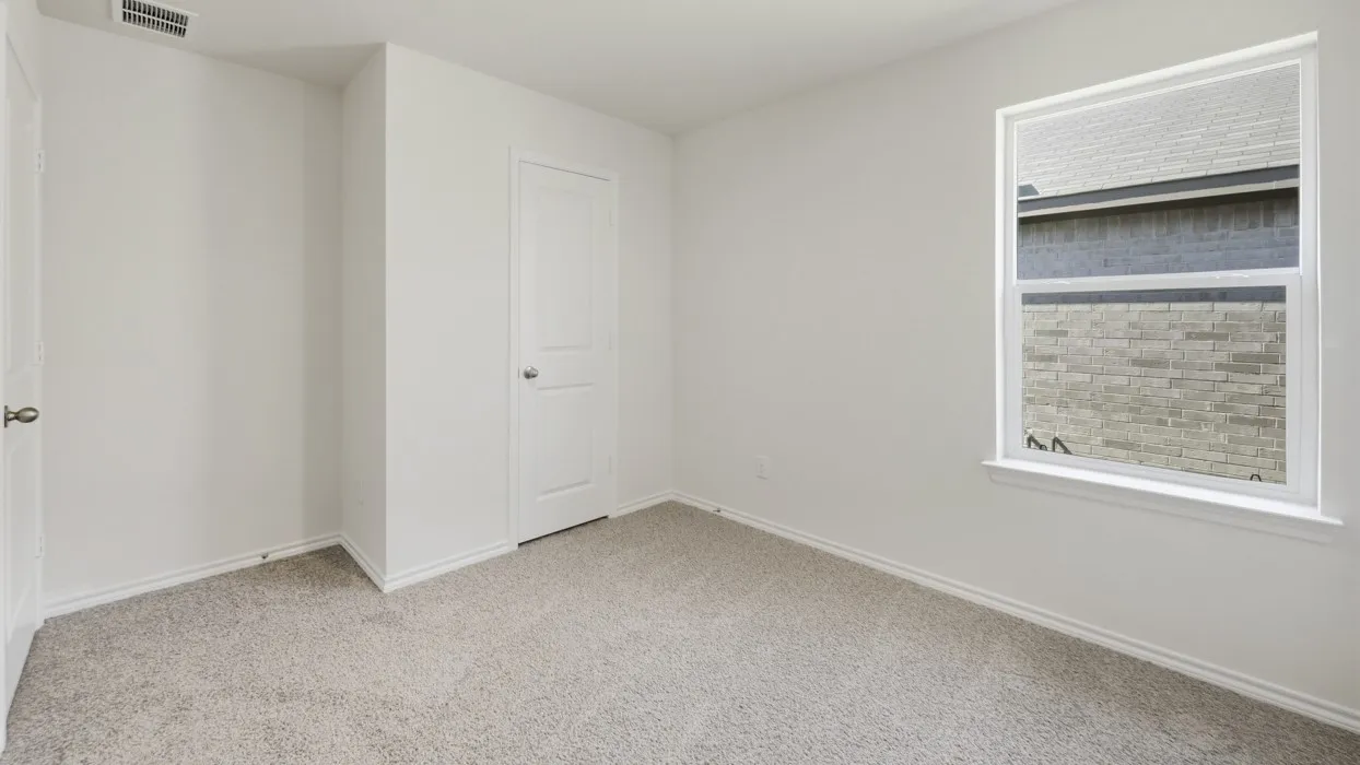 Bright room featuring a single window, light gray carpet, and white walls