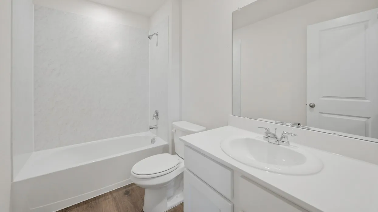 Bathroom featuring a white vanity with an integrated sink, chrome faucet, and a large wall-mounted mirror