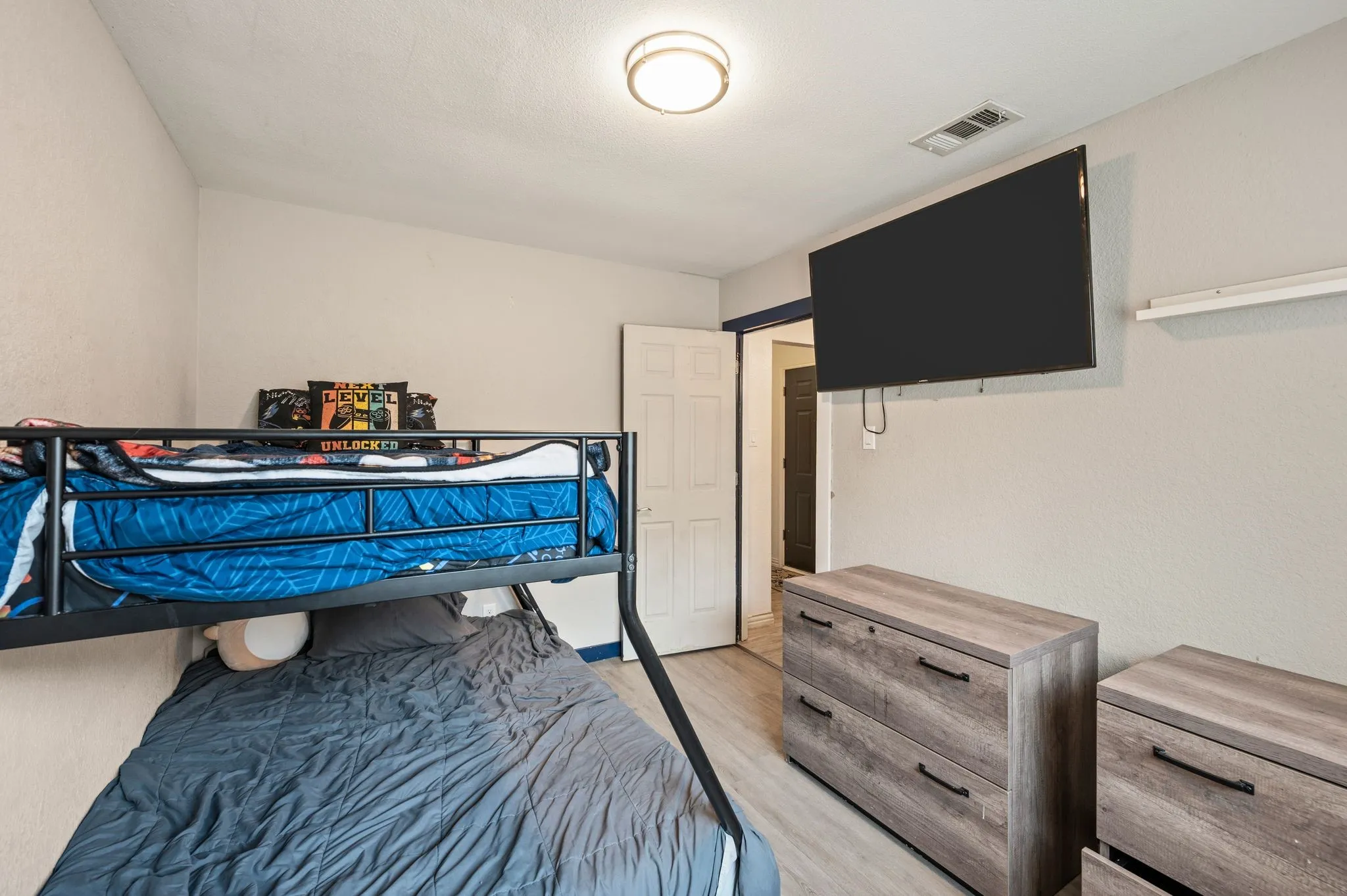 Bright room featuring light wood-finish flooring, neutral wall paint, and a flush-mount ceiling light