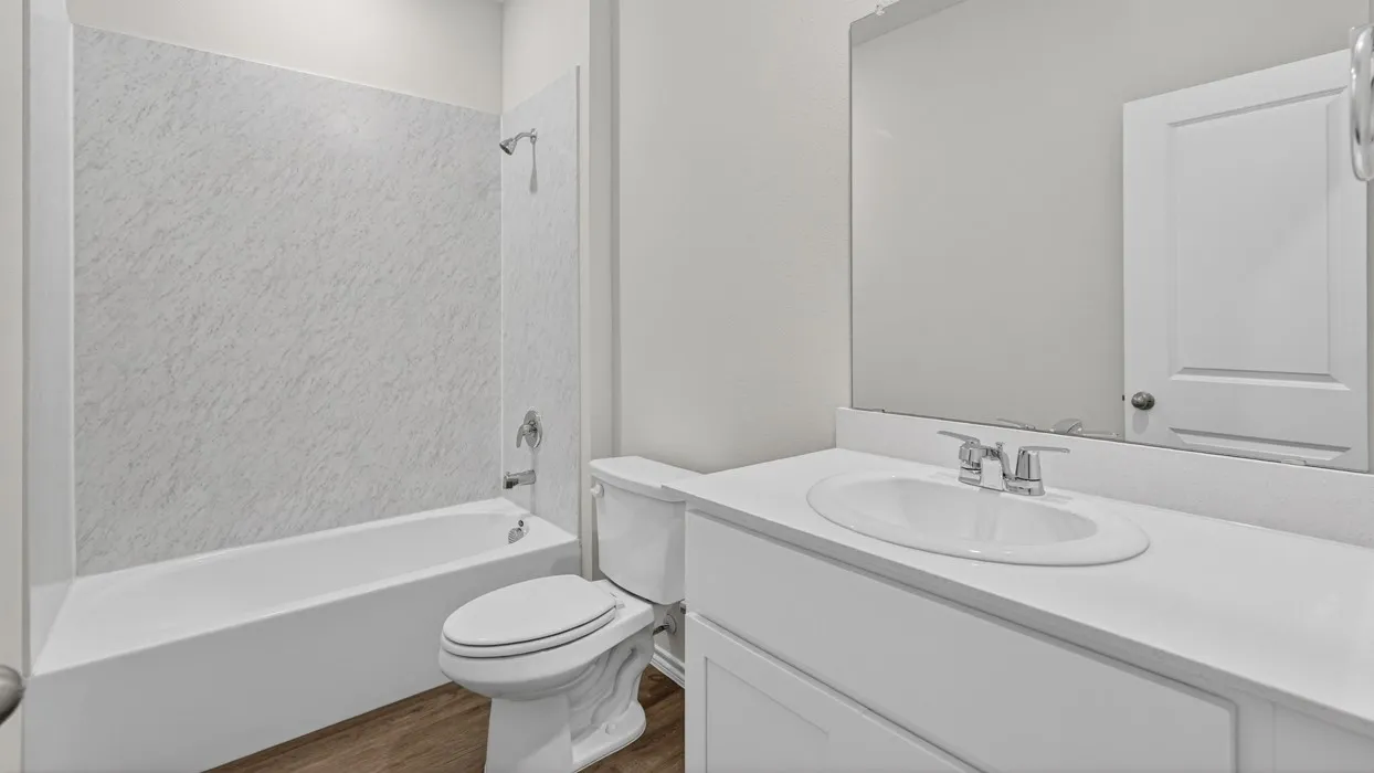 Bathroom featuring a single vanity with an integrated sink, polished chrome faucet, and expansive wall mirror