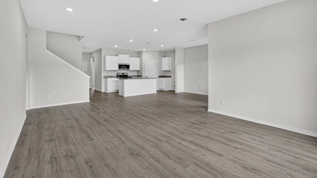 Expansive open-concept living area featuring wood-finish flooring, recessed lighting, and a neutral wall palette