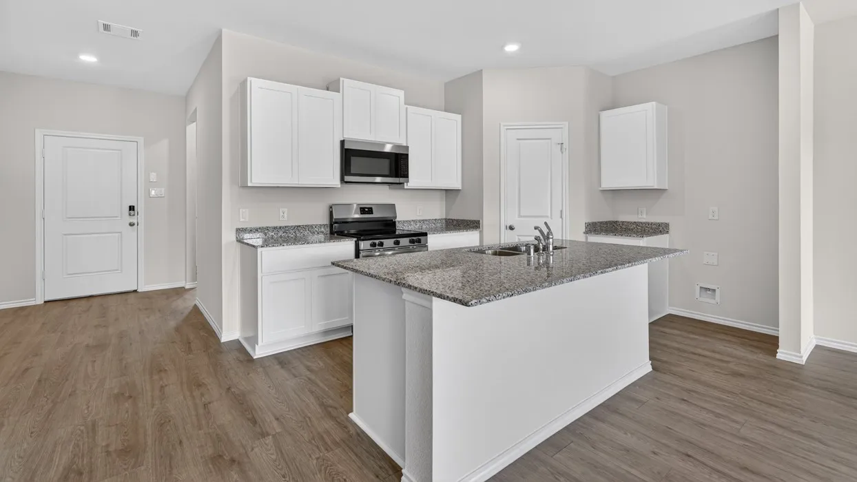 Kitchen featuring an island with a dual-basin sink, stainless steel appliances, granite countertops, white cabinetry, and wood-finish flooring