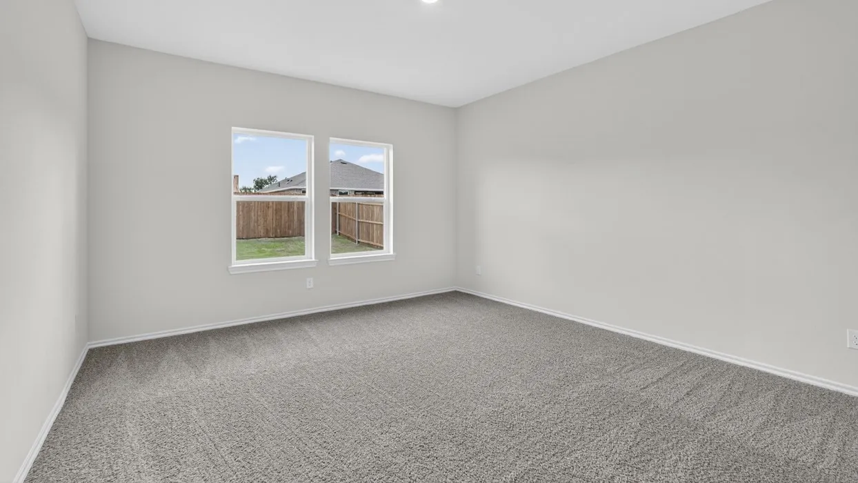 Spacious room featuring neutral carpeting, light gray wall paint, and two double-hung windows