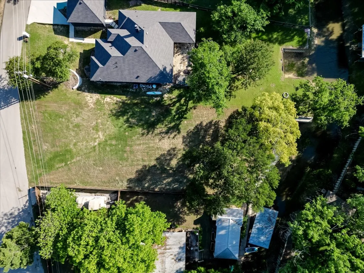 Expansive land parcel featuring direct waterfront access with a retaining wall and mature trees