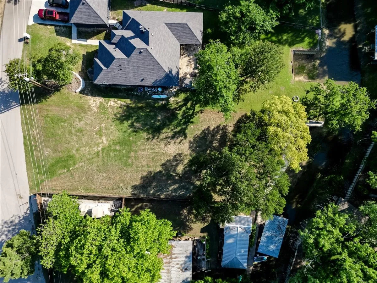 Expansive land parcel featuring a grass lawn, mature trees, and substantial open space