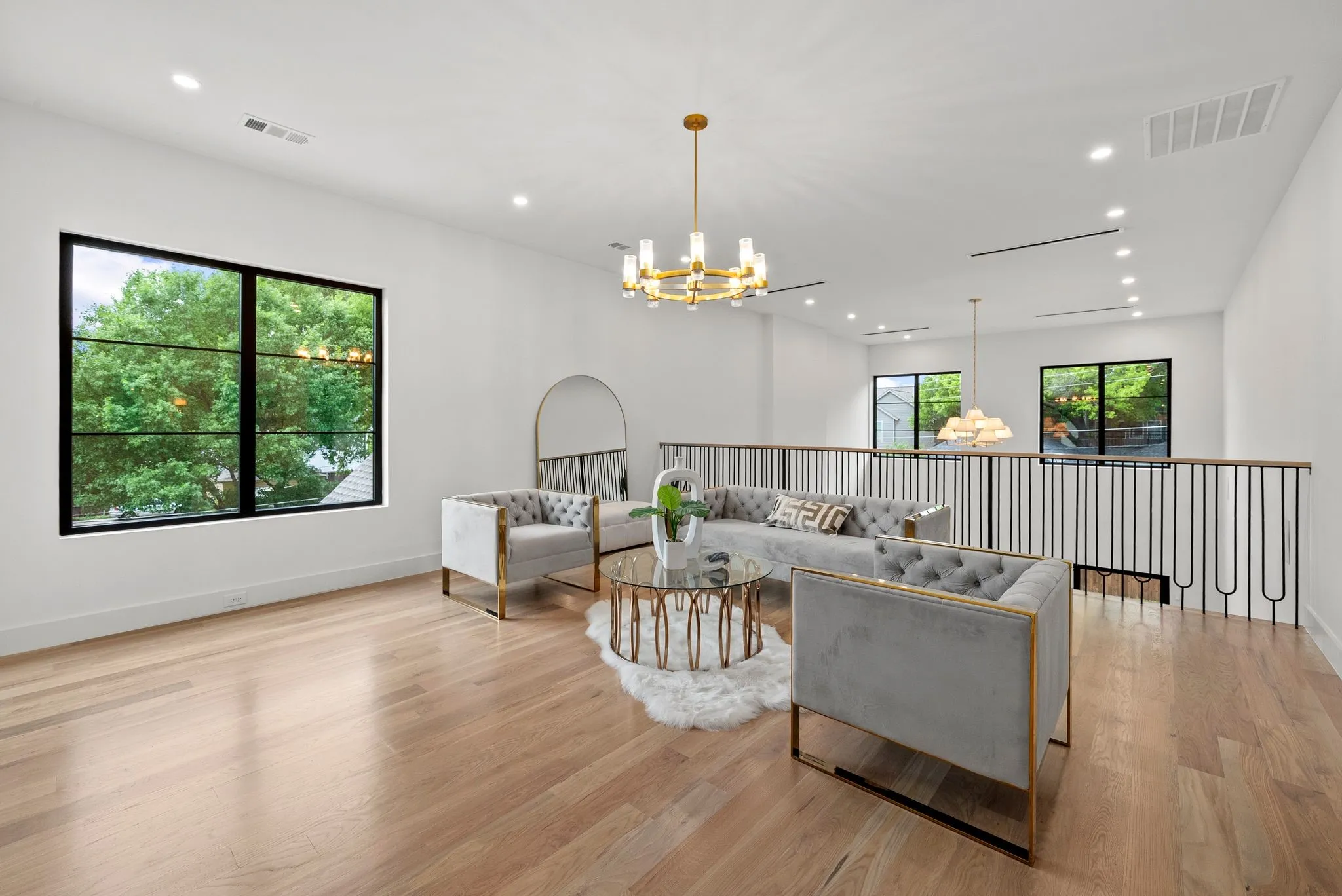 Open loft area featuring wide plank wood-finish flooring, recessed lighting, and a contemporary chandelier