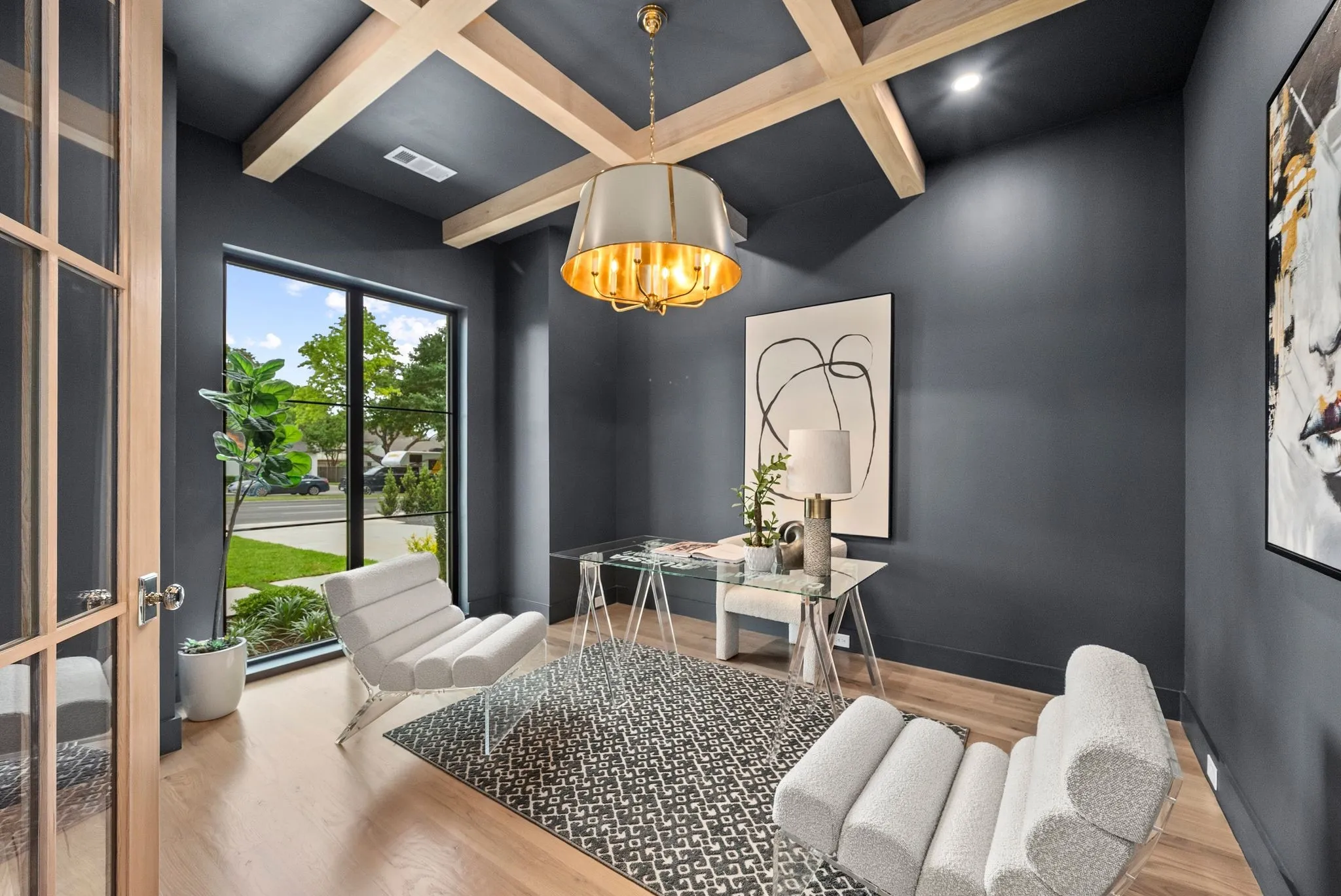 Room featuring a coffered ceiling with wood beams, dark accent walls, and wood-finish flooring