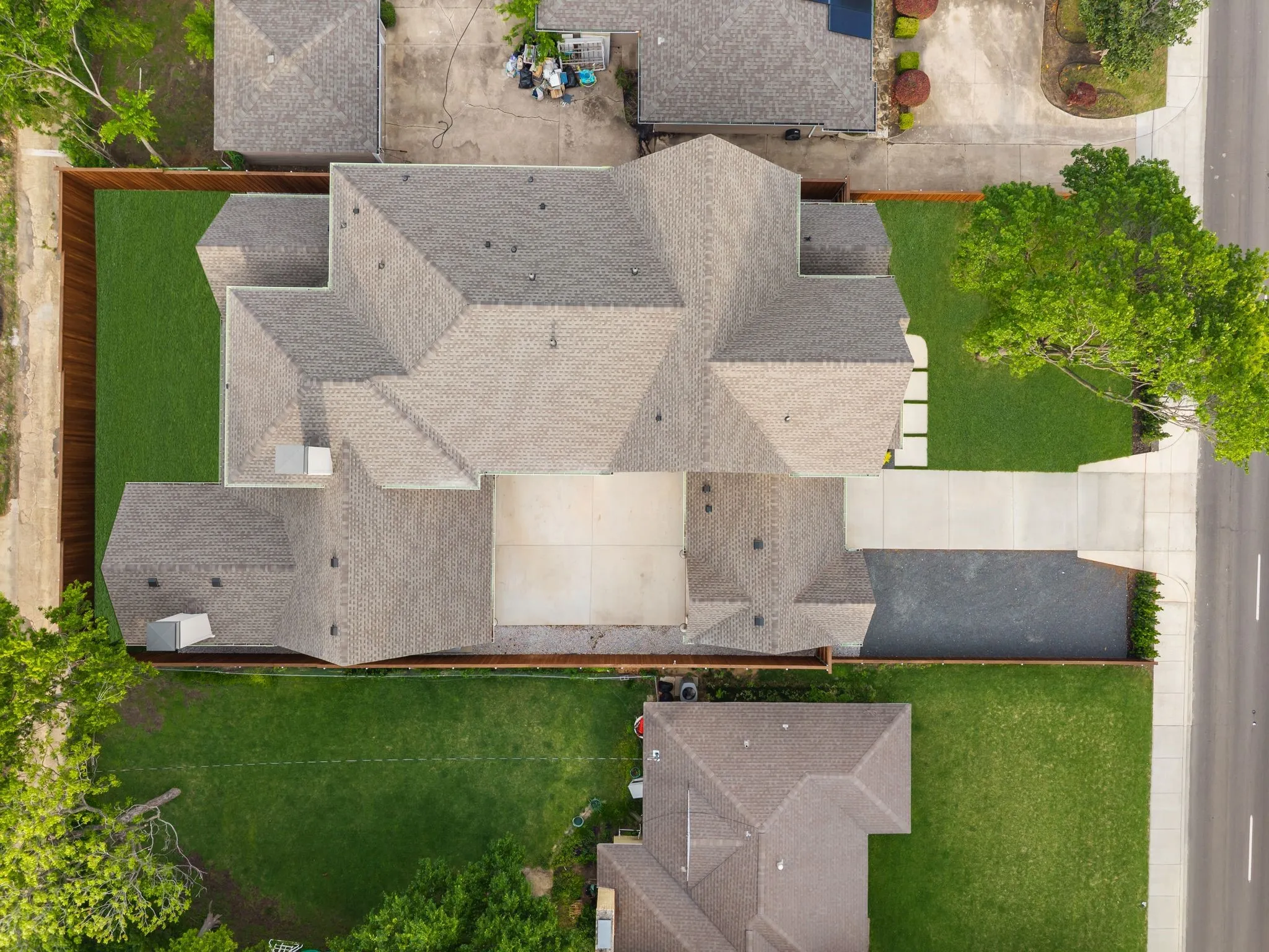 Expansive aerial showcasing a residential property with a multi-gabled roofline and a large, manicured lawn