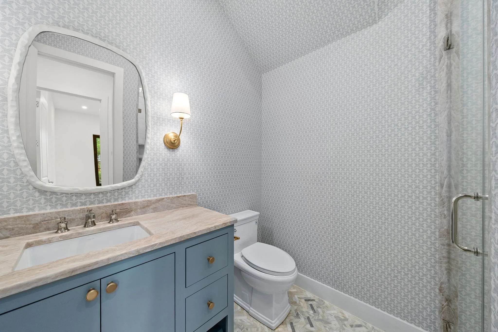 Vanity featuring a built-in sink, stone countertop, and blue cabinetry with brass hardware