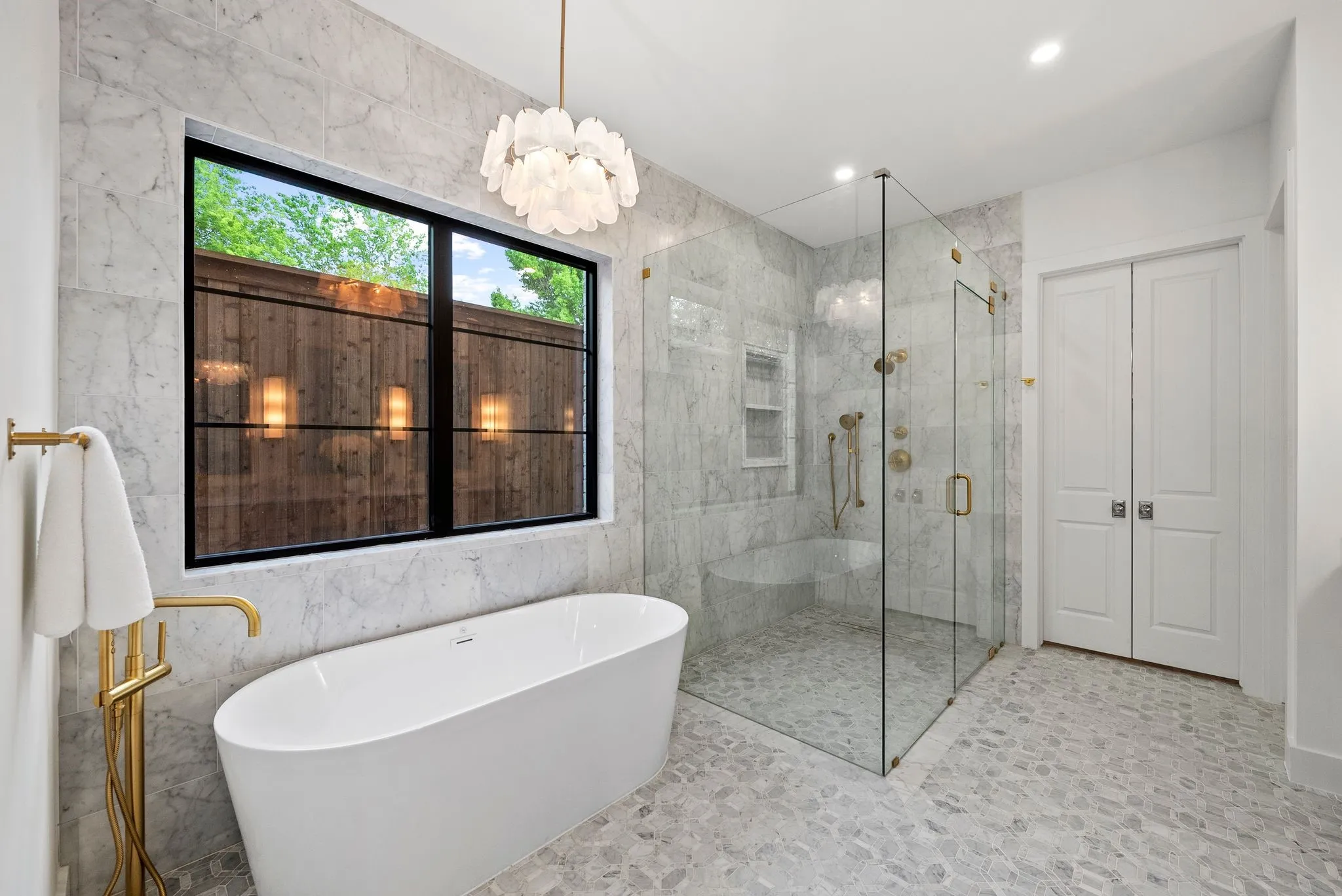 Freestanding soaking tub with gold-finish floor-mounted faucet