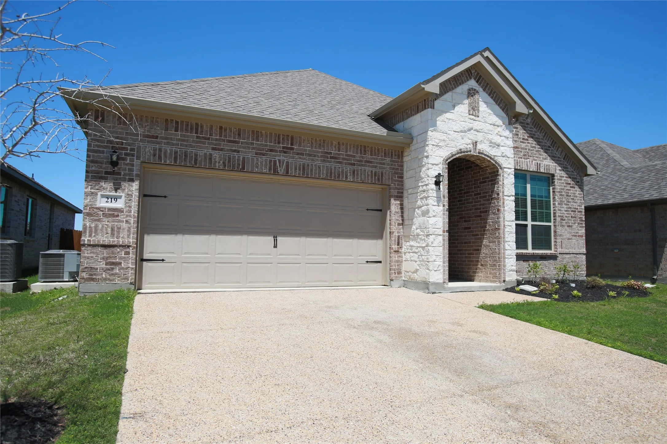 Brick and stone exterior featuring an arched entryway