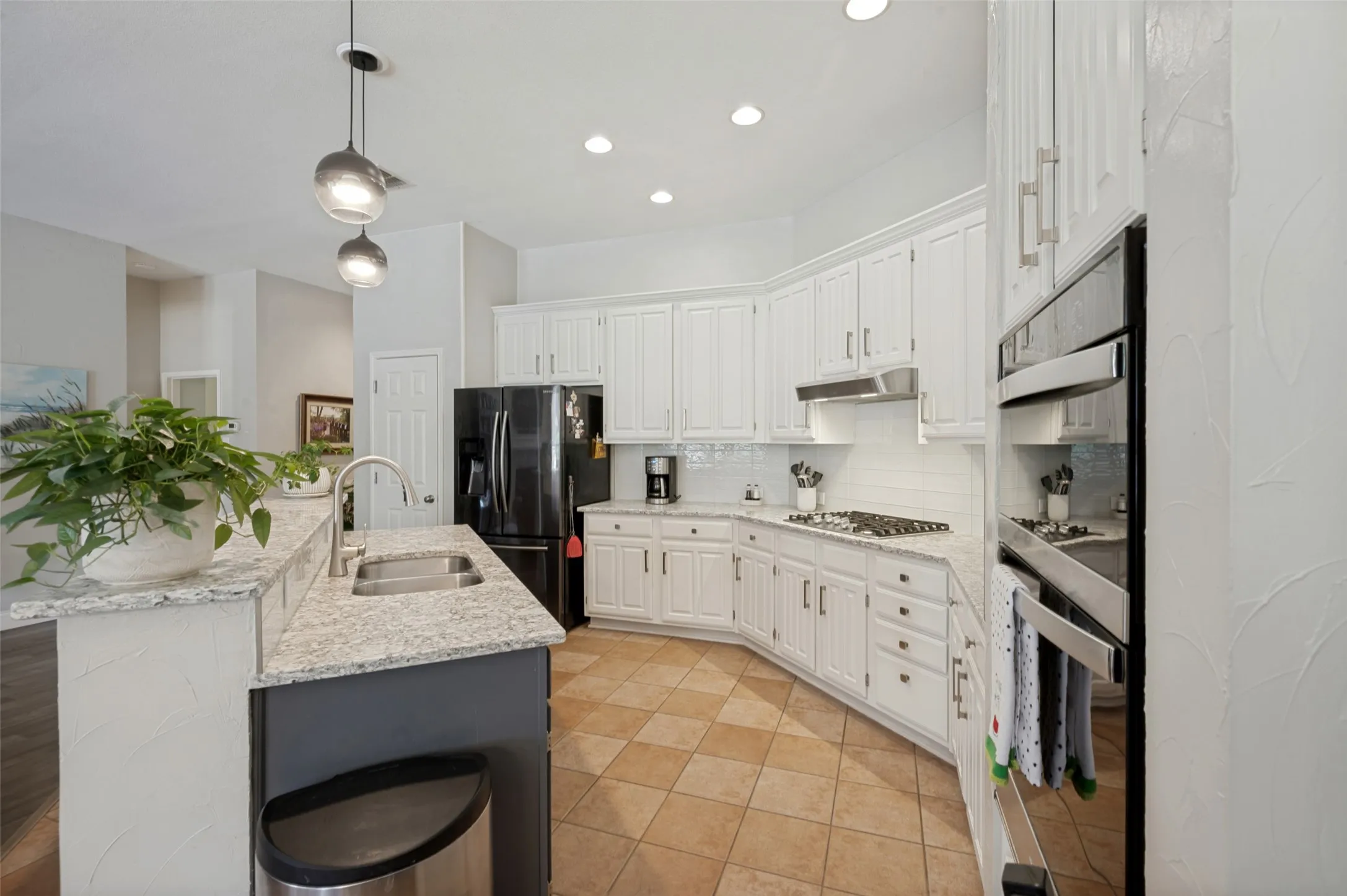 Open kitchen to living & breakfast room with view of pool and yard