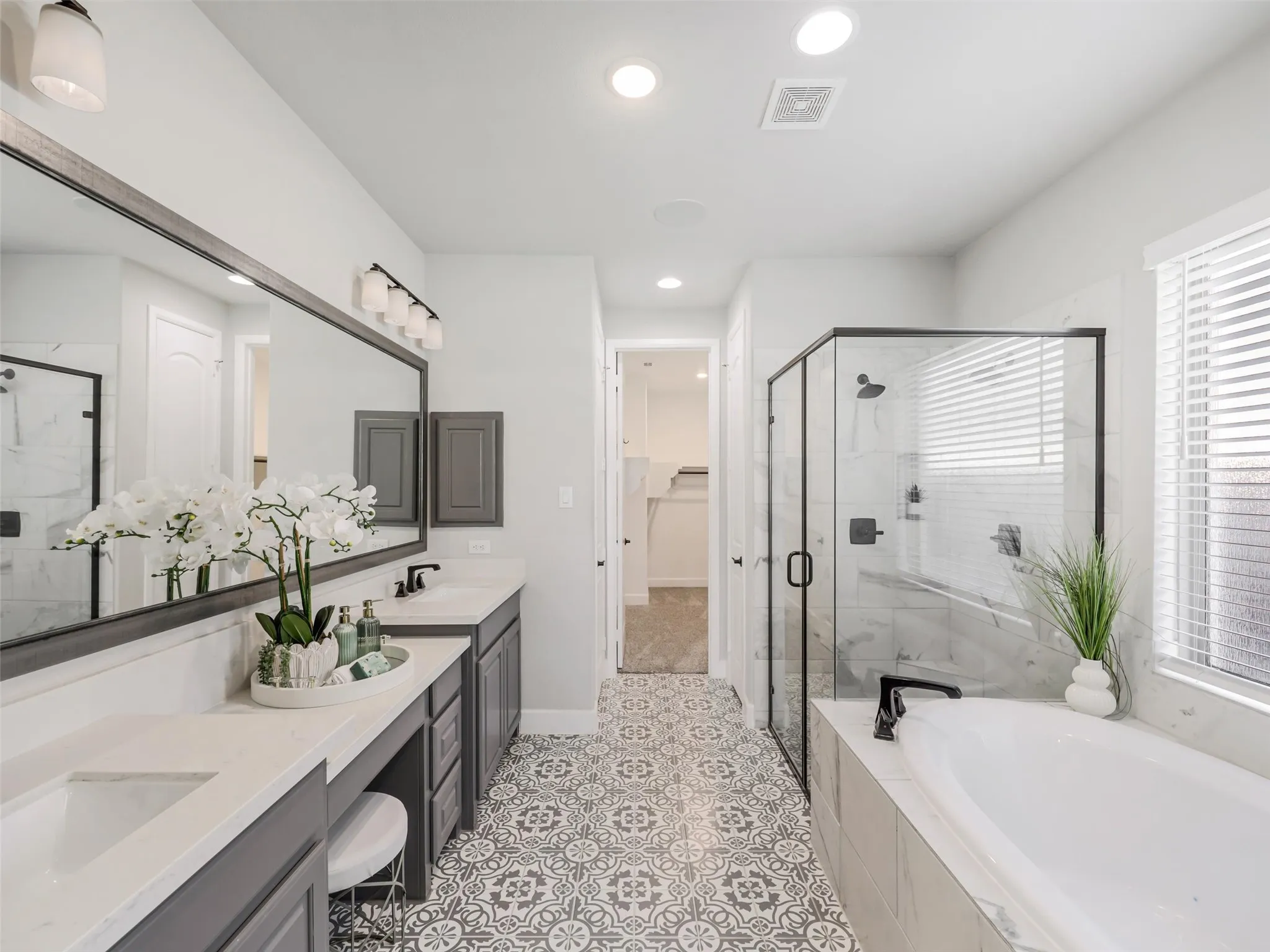 Spa-inspired finishes - Frameless glass shower,
Soaking tub, designer patterned tile flooring, and abundant natural light
