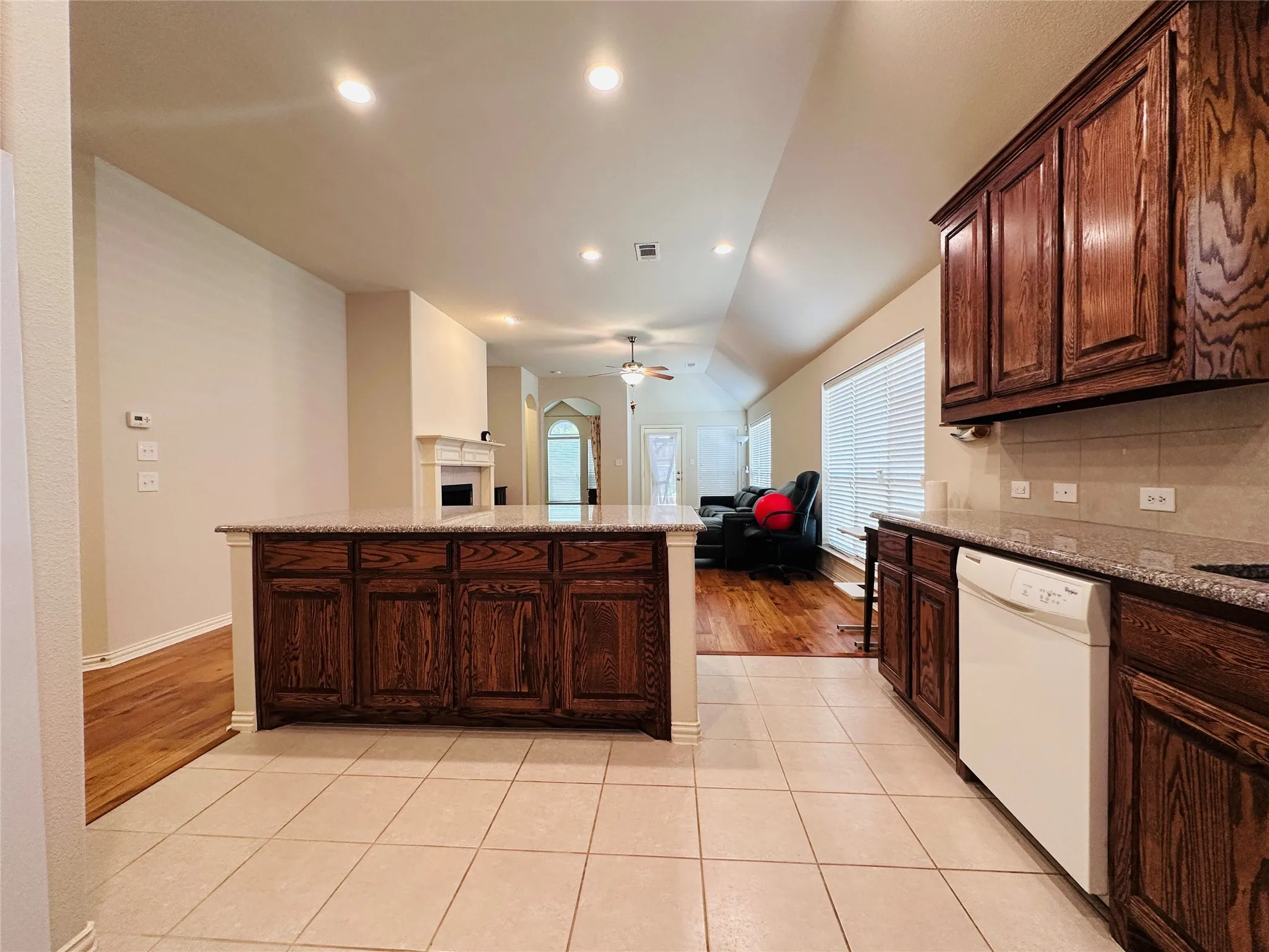 Kitchen featuring a central island with wood cabinetry, granite-style countertops, and tile flooring
