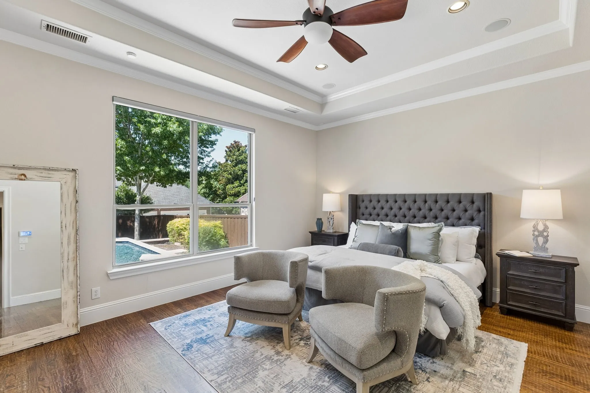 The hardwood floors and detailed crown moulding continue into the primary suite. Complete with a lovely view of the backyard oasis!