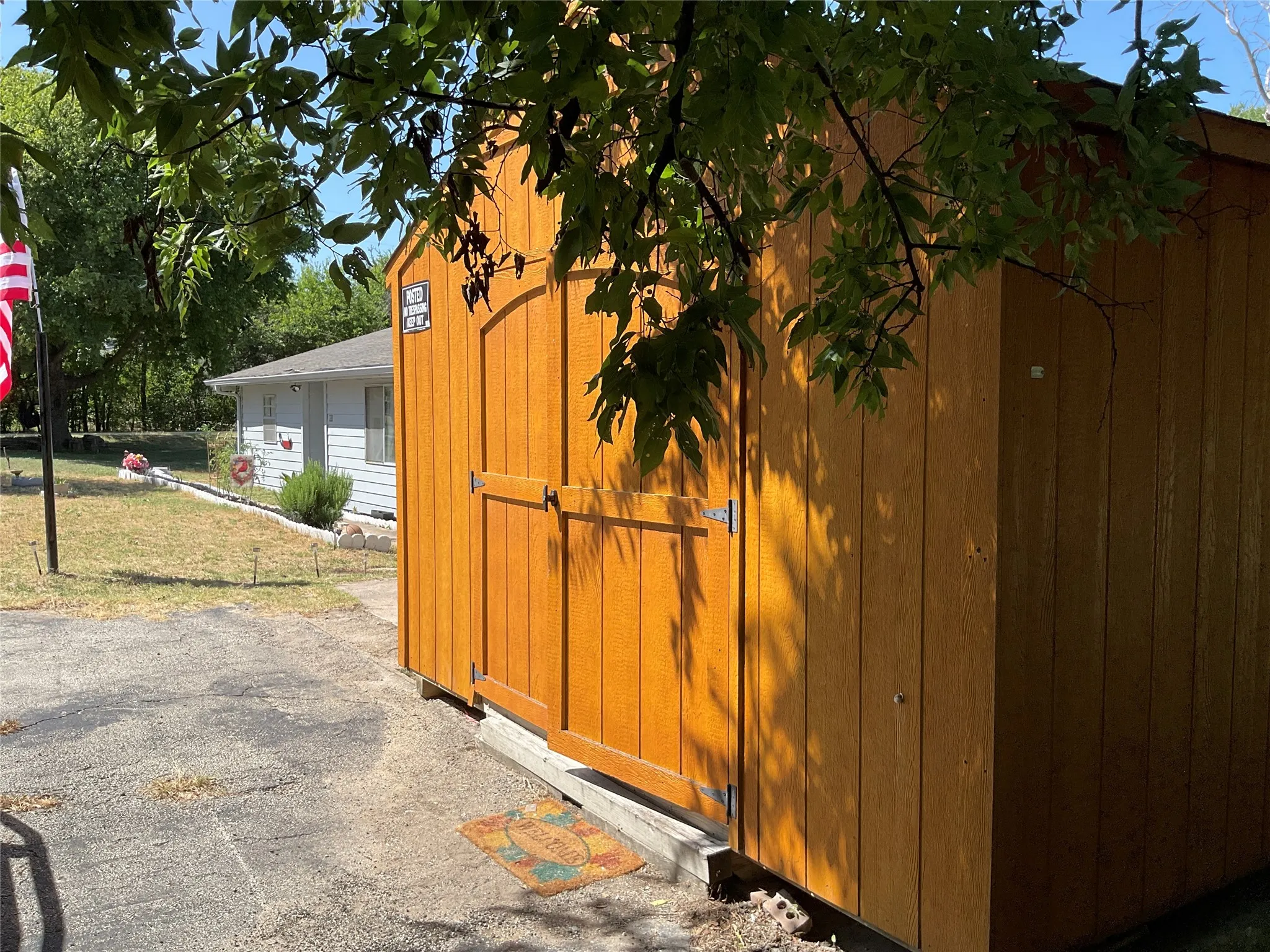 Freestanding wooden shed featuring double doors and vertical wood siding