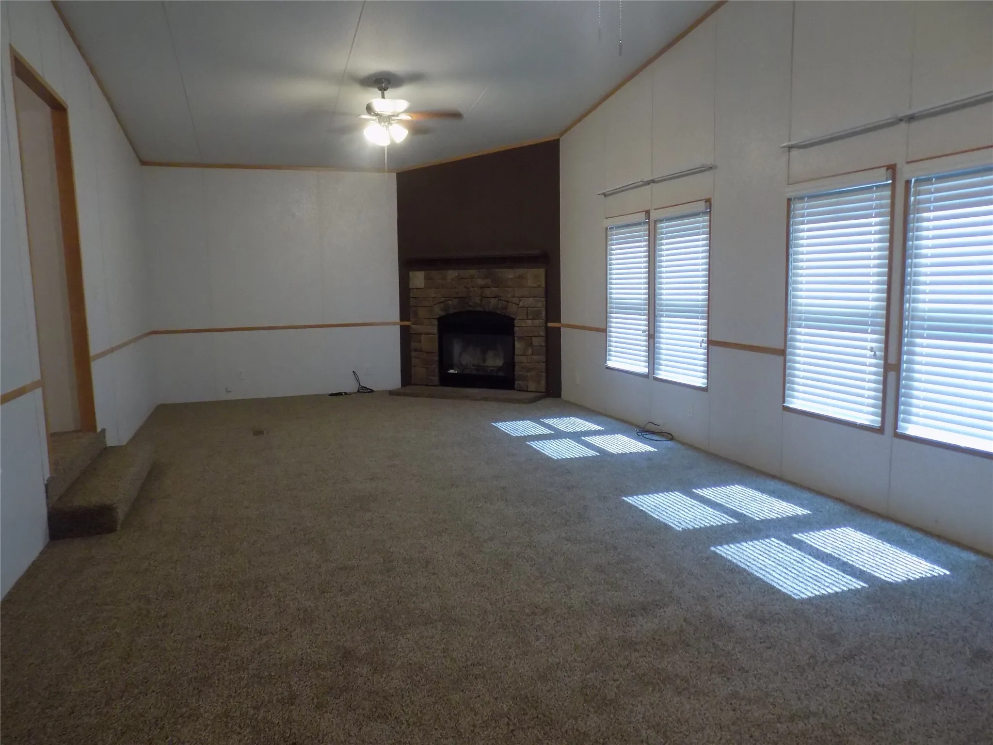Spacious den, 29' x 13', with multiple ceiling fans with lights and windows to give the room natural light, as well.
