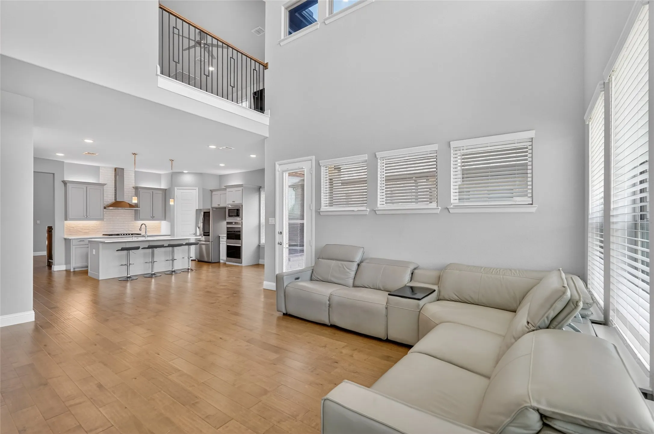 Open-concept living space featuring wood-finish flooring and high ceilings