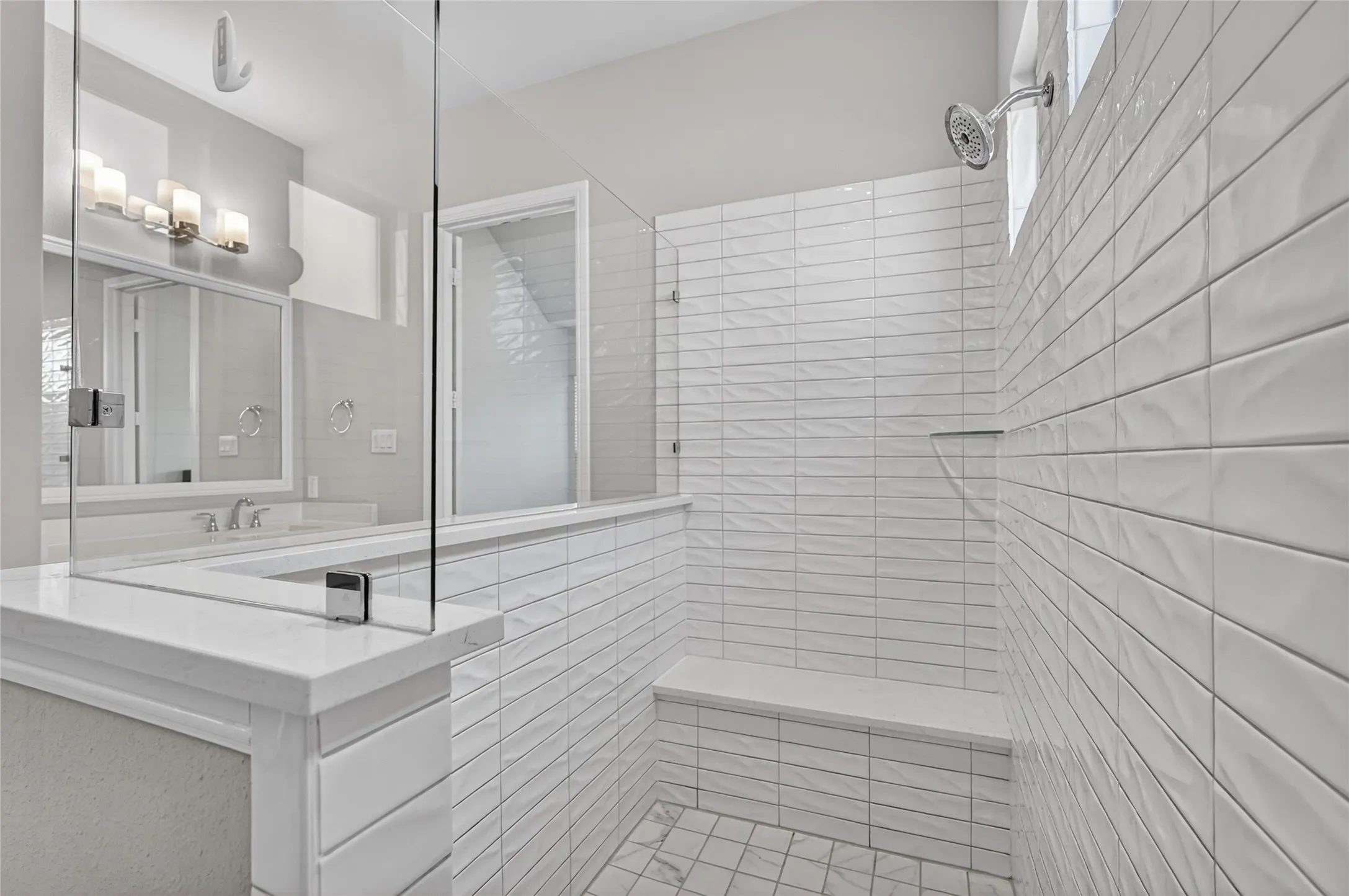 Walk-in shower featuring a built-in bench, white subway tile walls with textured accents, and a glass enclosure