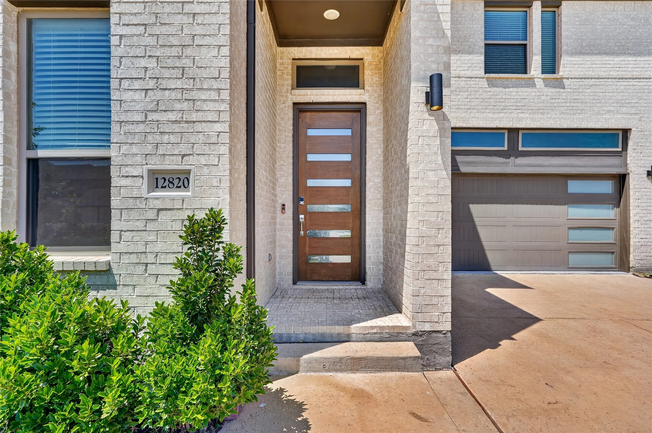 Modern brick exterior with a contemporary front door featuring horizontal glass panels
