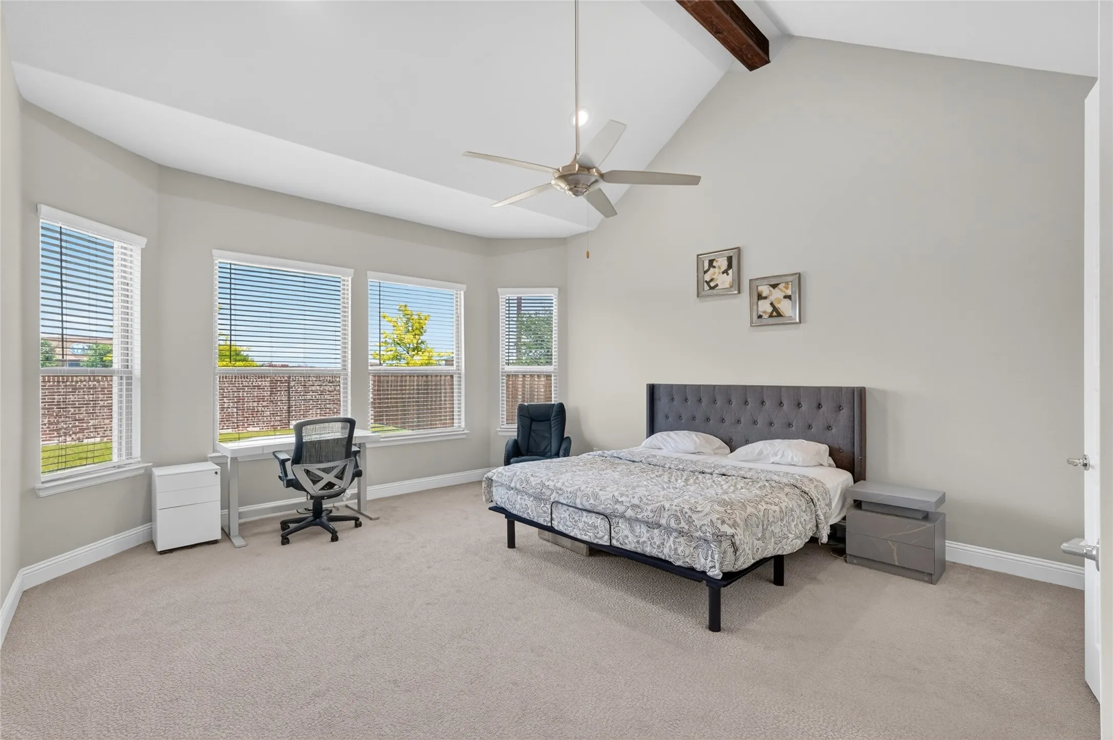 Bedroom featuring vaulted ceilings with exposed wood beams and a ceiling fan