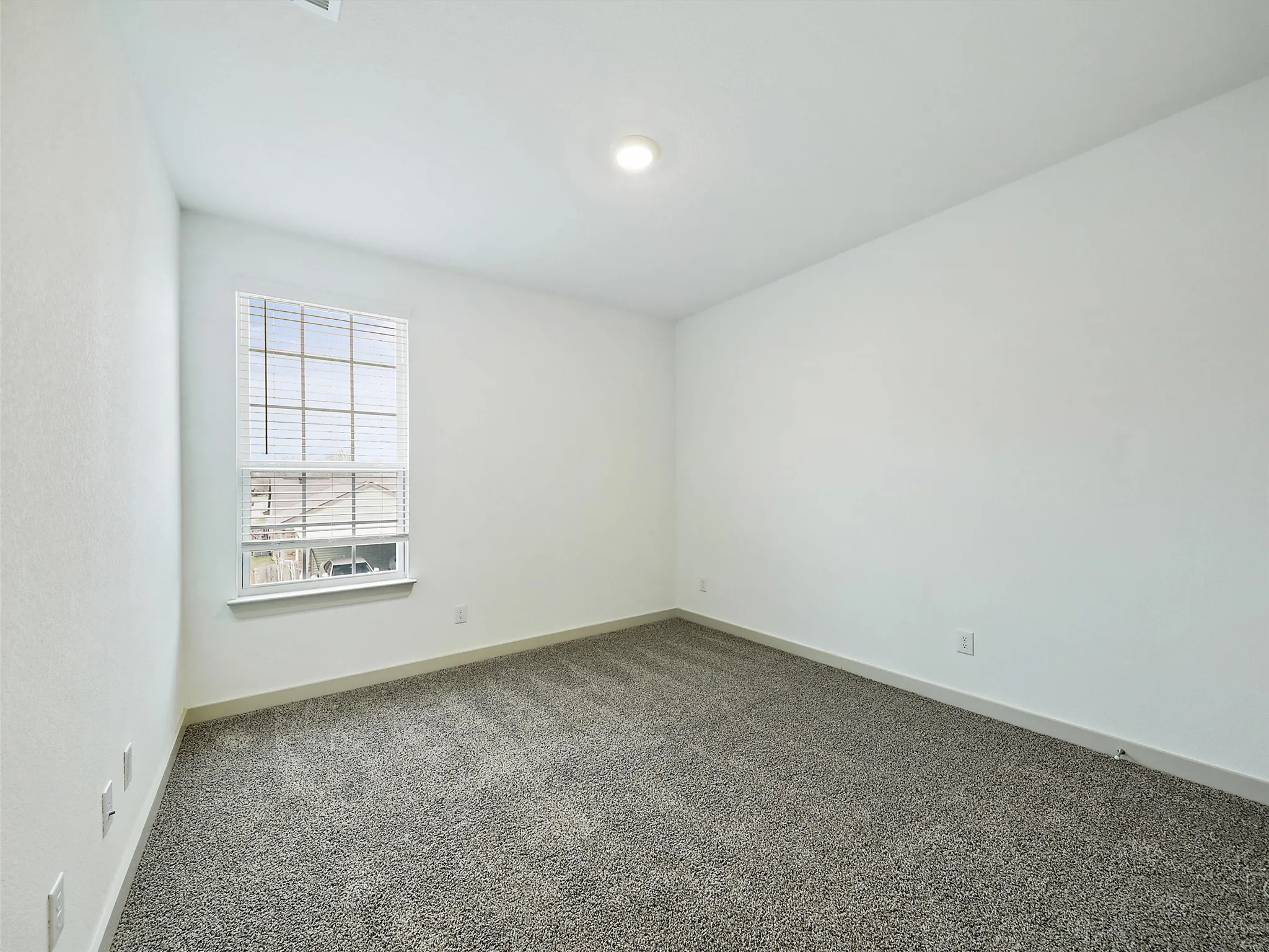 Carpeted room with a single window featuring horizontal blinds