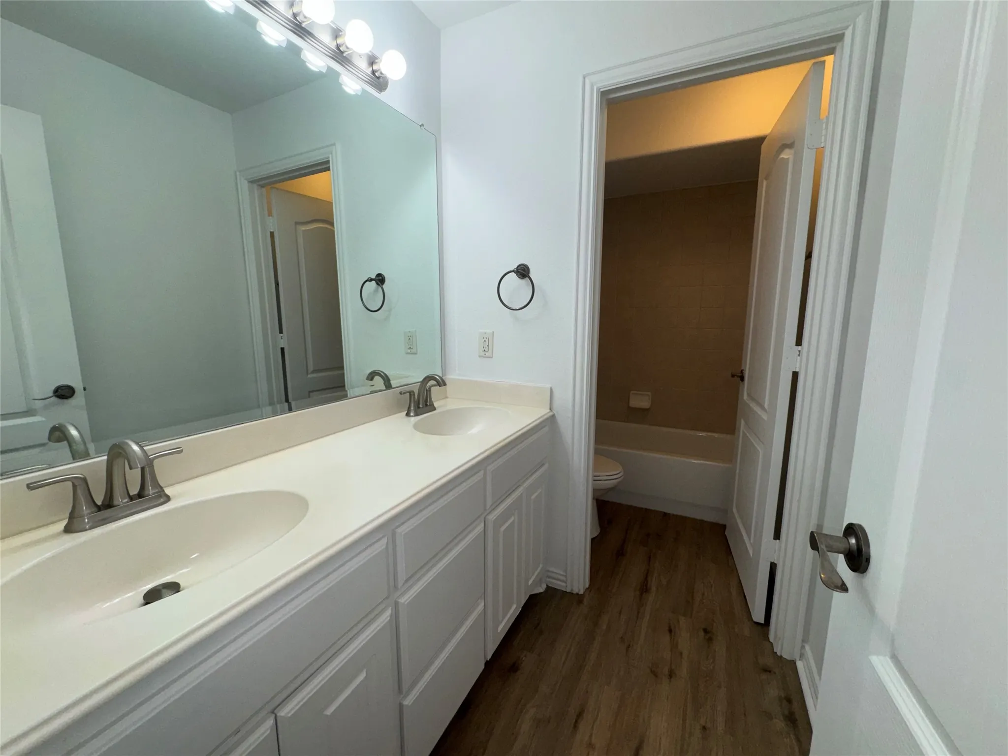 Dual-sink vanity with white cabinetry, undermount basins, and brushed nickel hardware