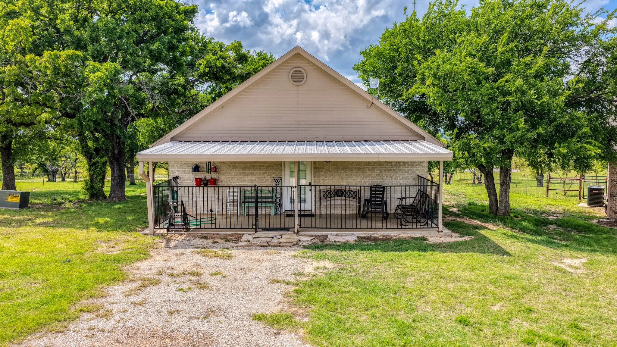 Gable-roofed home featuring a covered front porch with a metal roof