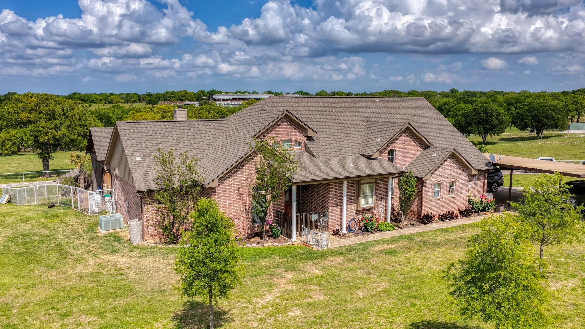 Expansive brick-clad residence featuring a dormer window, covered front entry, and a multi-pitched shingle roof