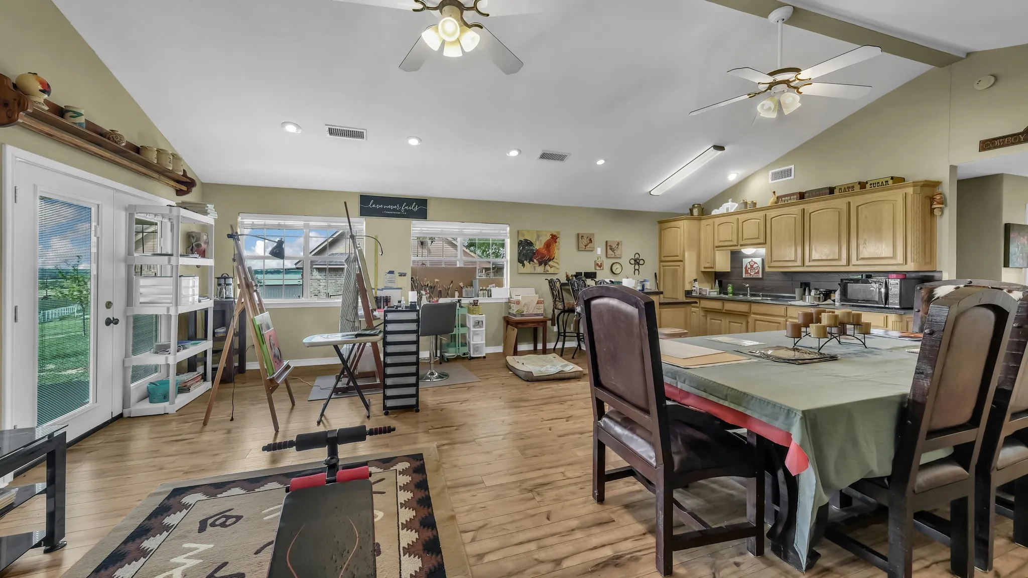 Expansive open-concept room featuring wood-finish flooring and vaulted ceilings