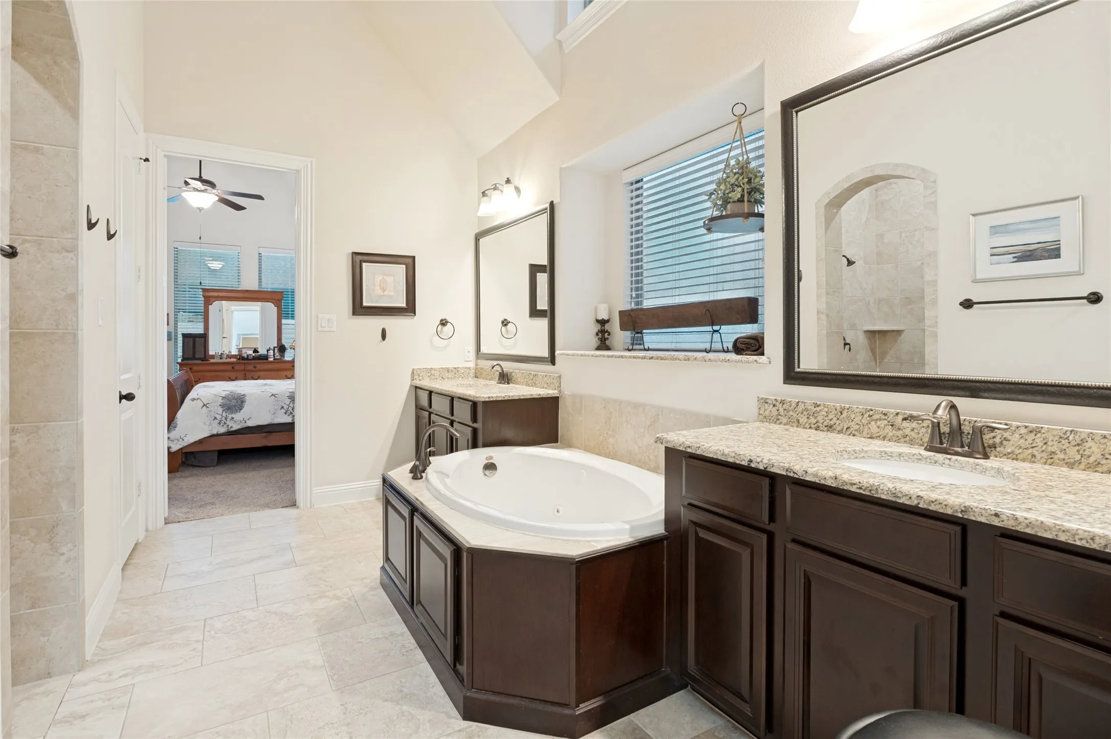 Spacious bathroom featuring a built-in soaking tub, dual vanity with undermount sinks, and stone countertops