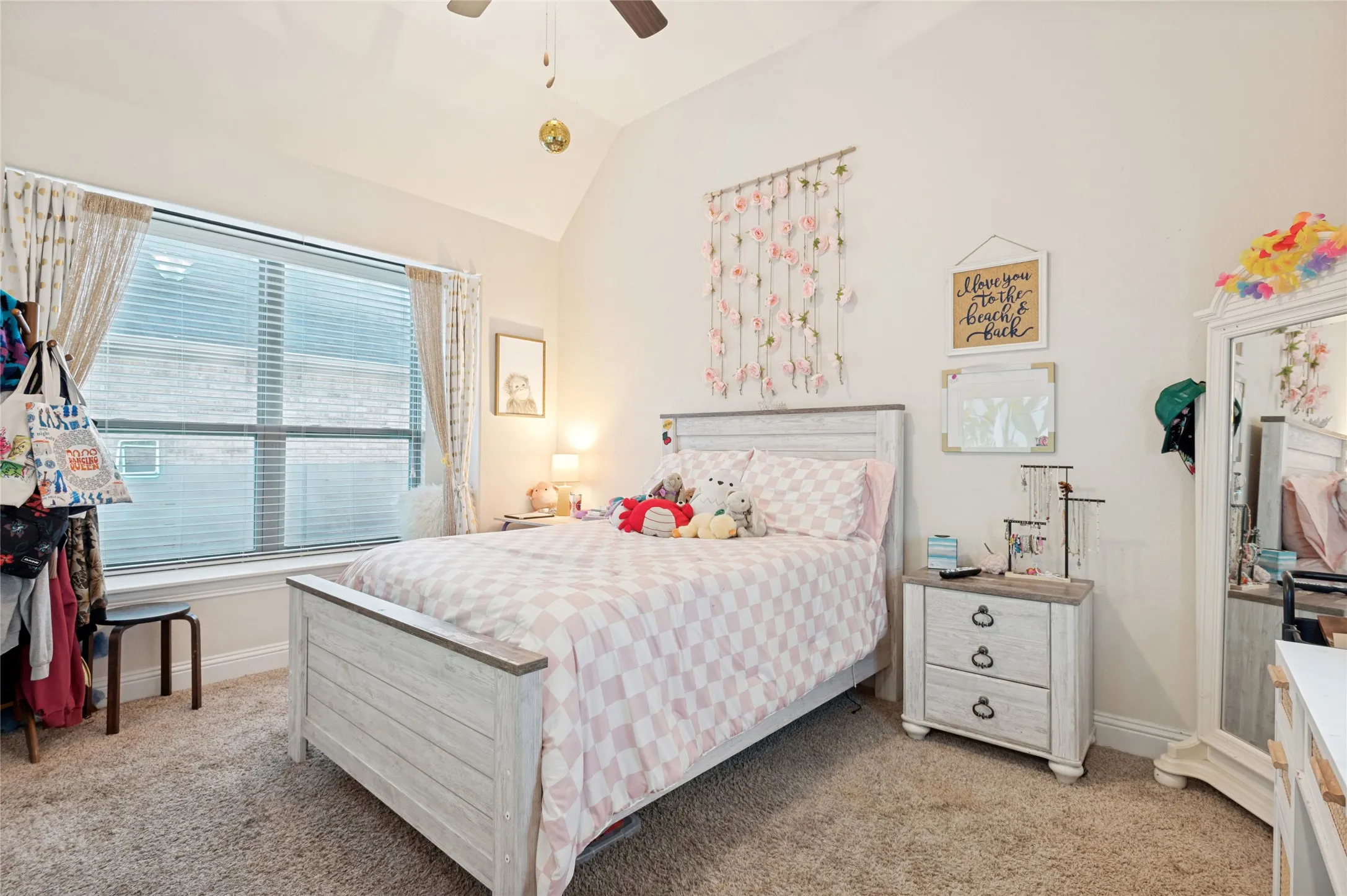 Vaulted ceiling room featuring carpet flooring and a large window with blinds