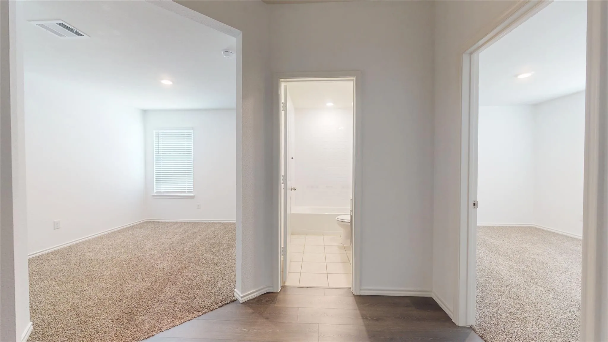 Interior hallway with wood-finish flooring, recessed lighting, and white trim