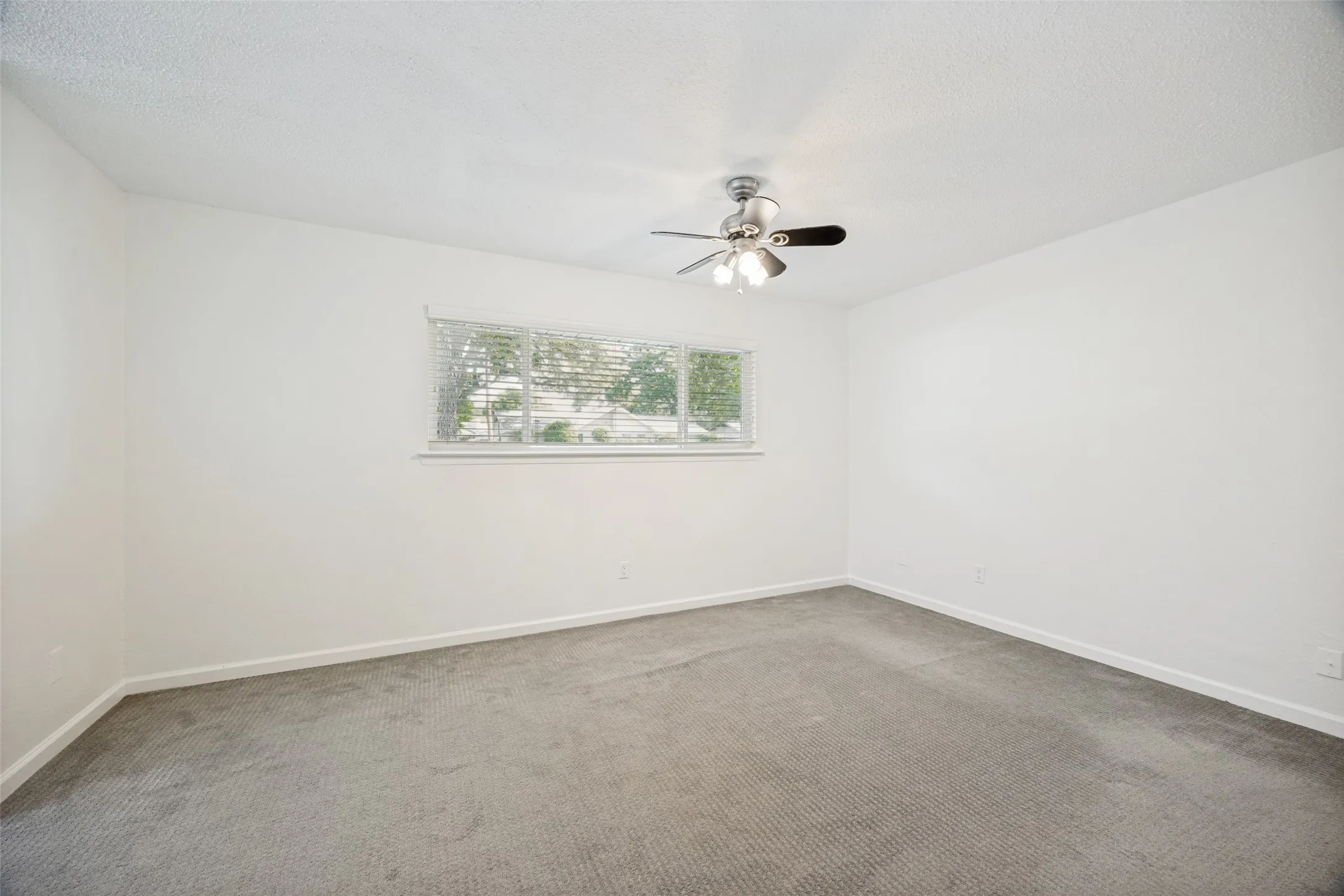 Spacious room featuring neutral carpeting and white walls
