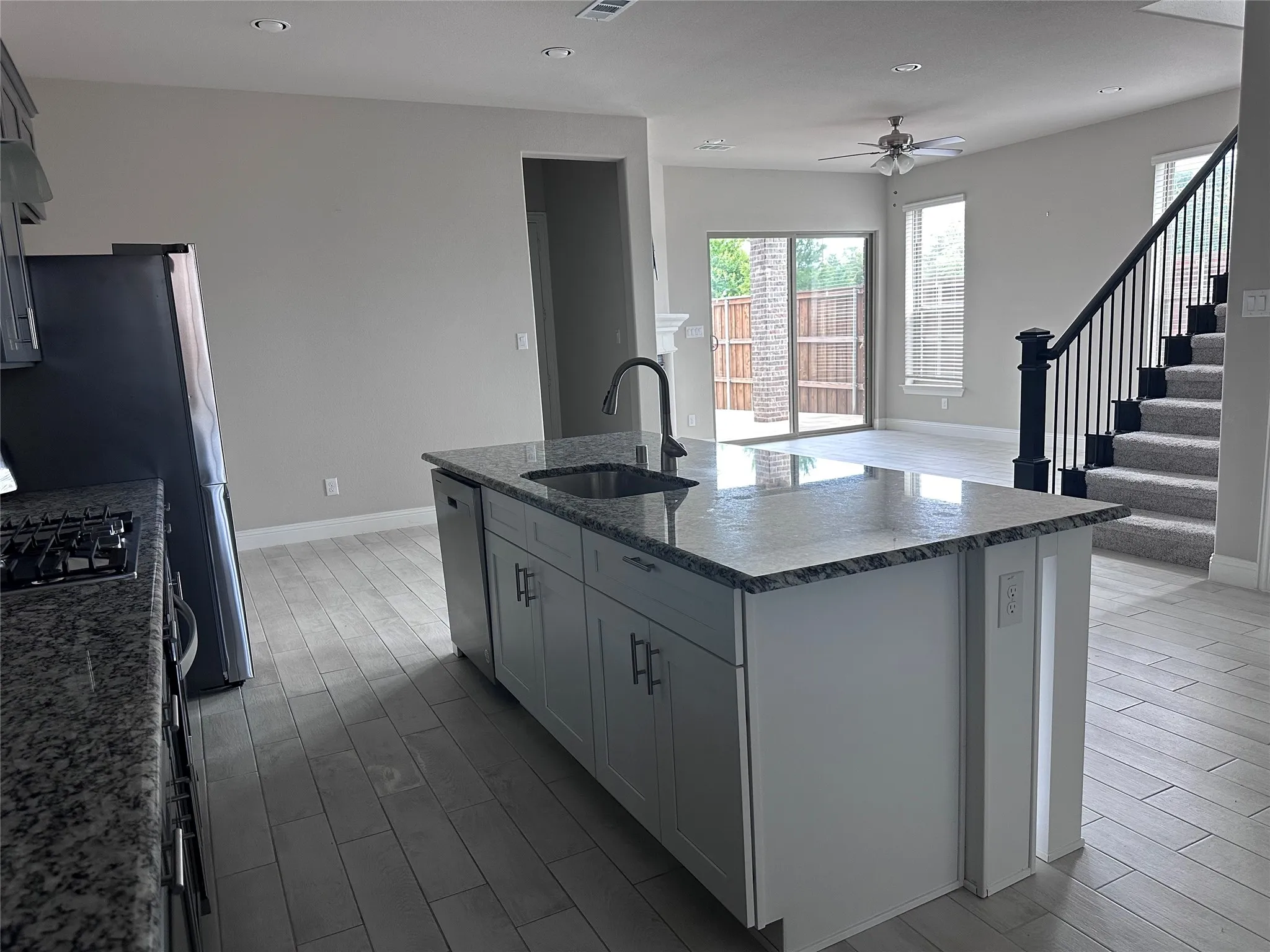 Modern kitchen island featuring a stainless steel sink and a contemporary faucet