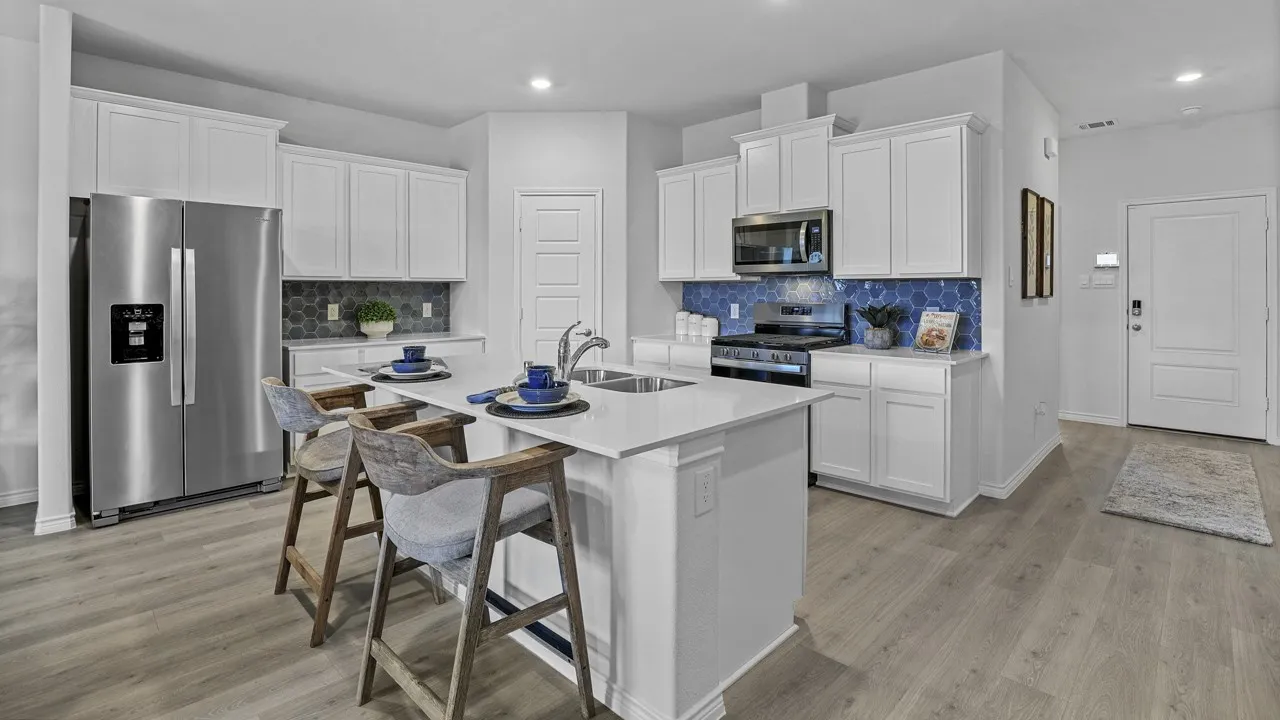 Contemporary kitchen featuring a center island, white cabinetry, stainless steel appliances, and a blue hexagonal tile backsplash