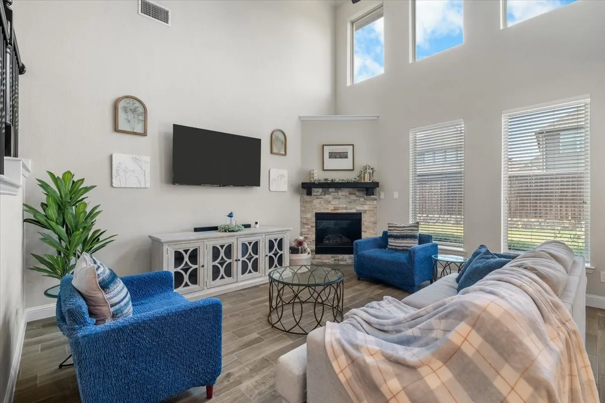 Spacious living room with soaring ceilings, expansive windows, and a gas-log fireplace