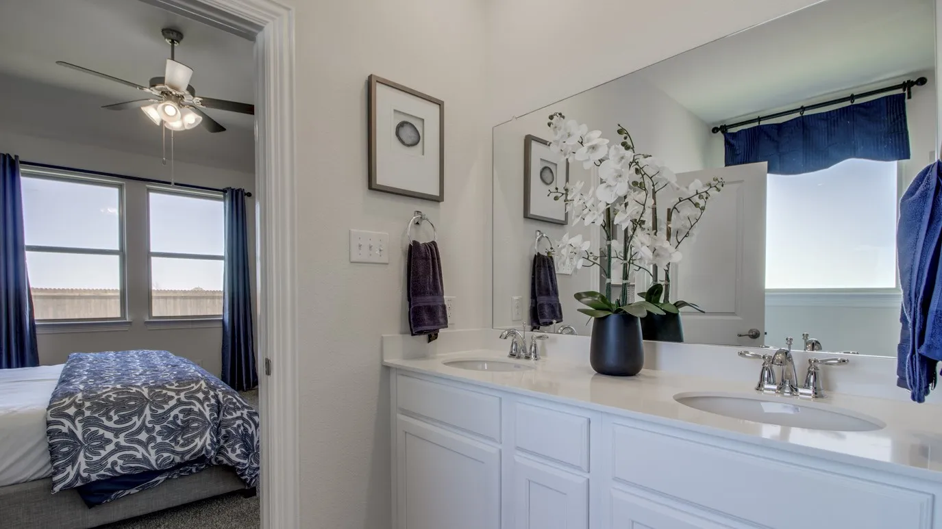 Double vanity featuring undermount sinks, chrome fixtures, and a light-toned countertop