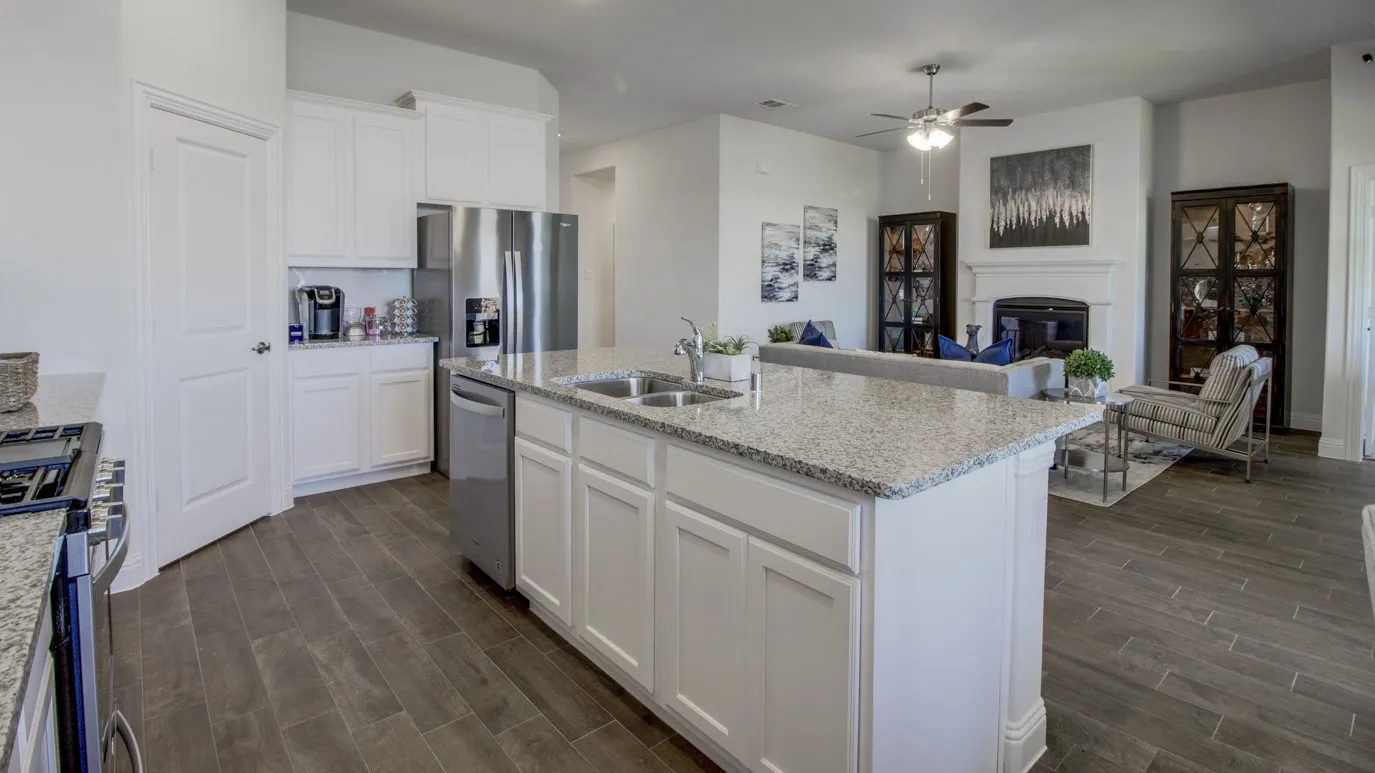 Open-concept living space with a central kitchen island featuring a dual basin sink and granite countertop