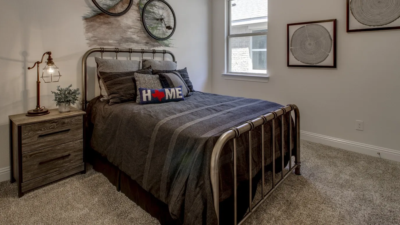 Bedroom featuring textured carpeting, a single window with white trim, and light-toned walls
