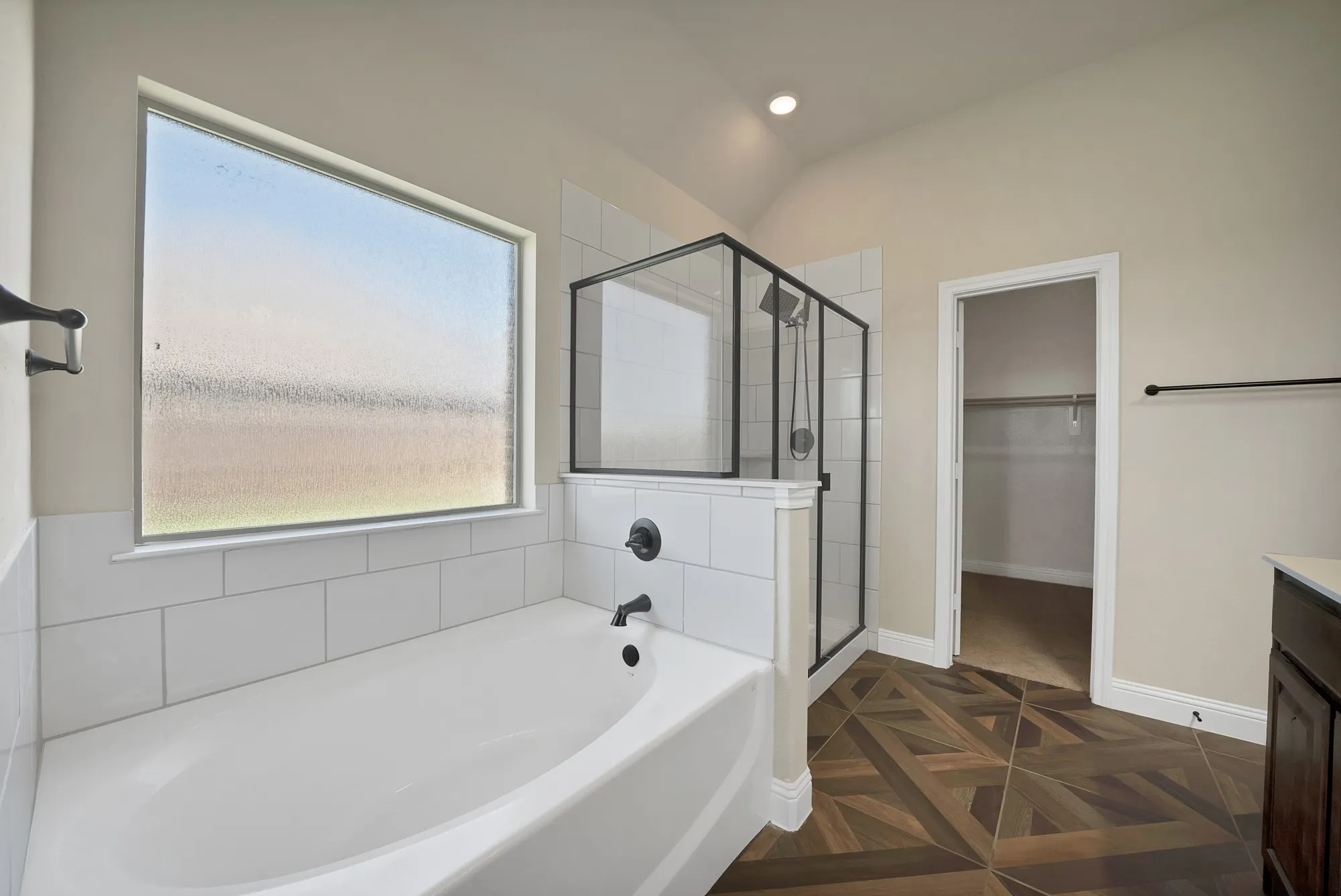 Soaking tub featuring matte black fixtures and white subway tile surround