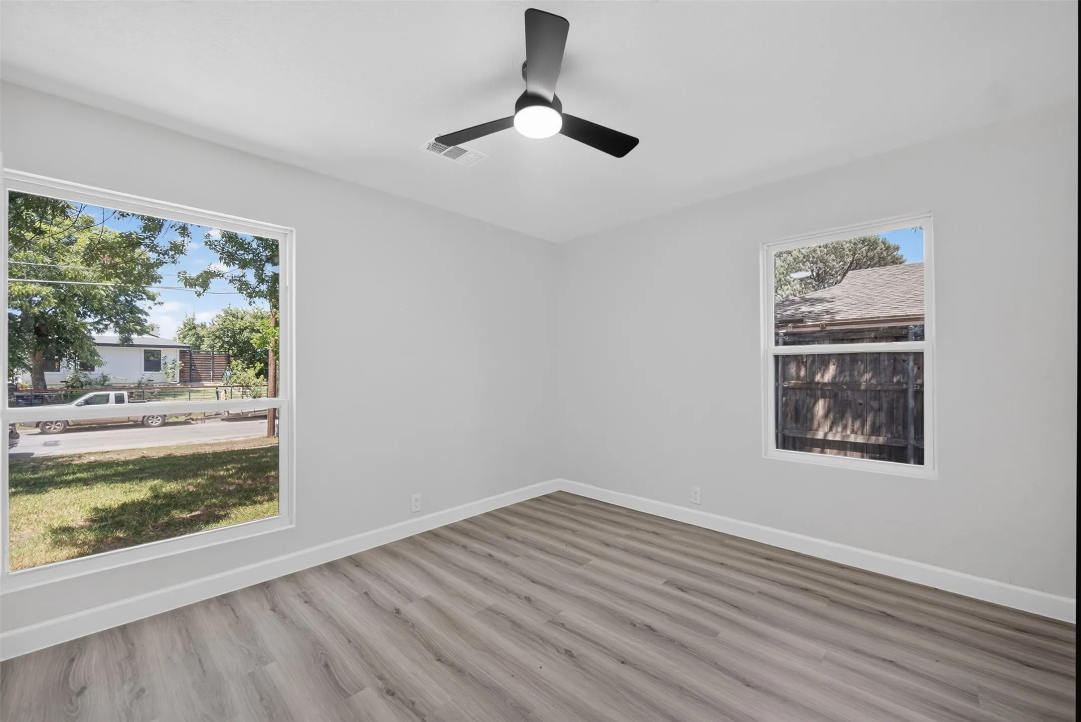 Interior space featuring wood-finish flooring, light gray walls, and white baseboards